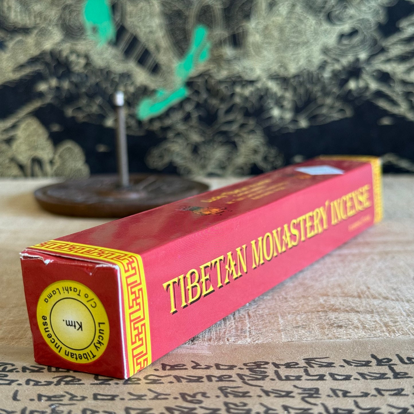 Box of Tibetan Monastery Incense on a textured surface with a blurred background