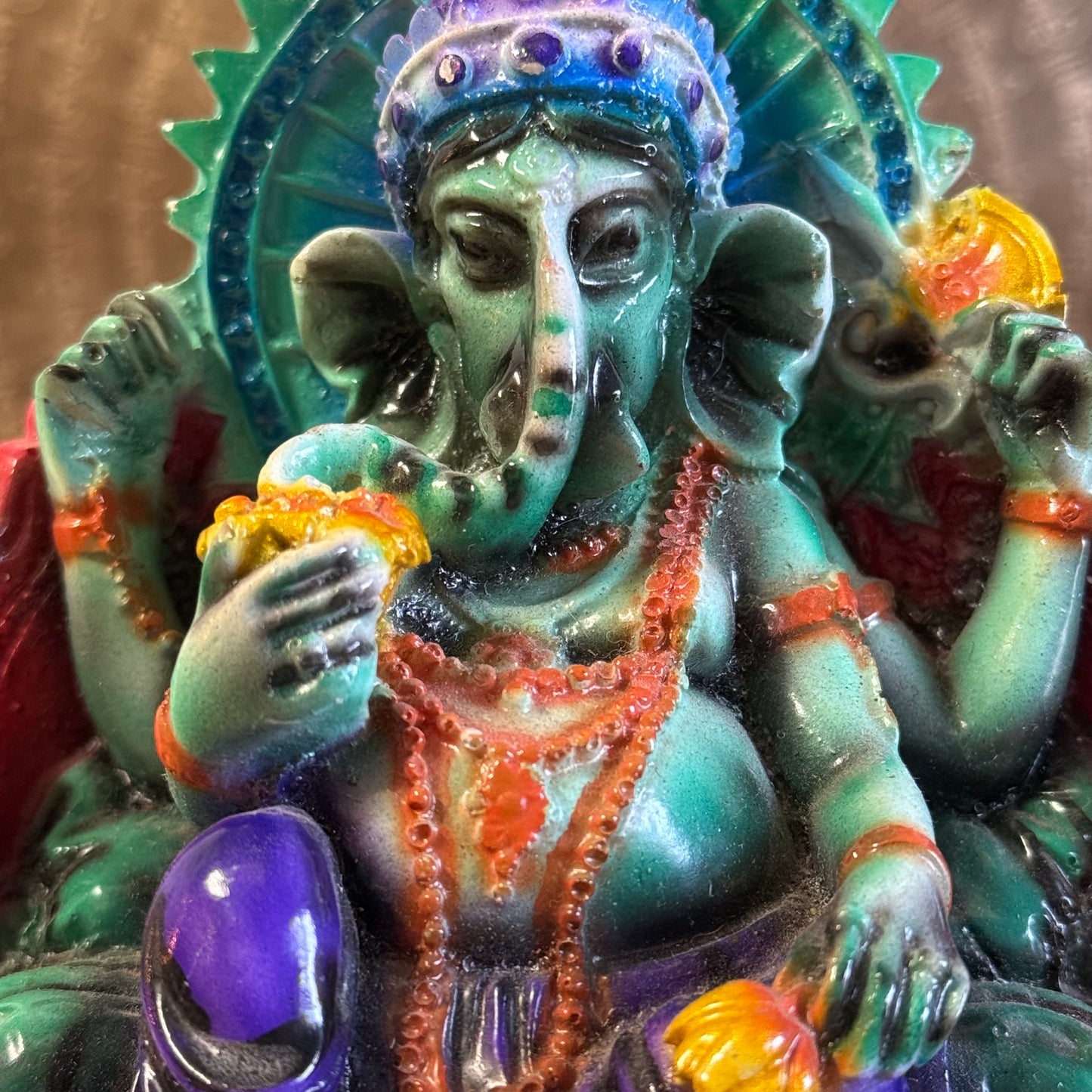 Hand-painted 15 cm resin Ganesh statue holding lotus, axe, and sweets.