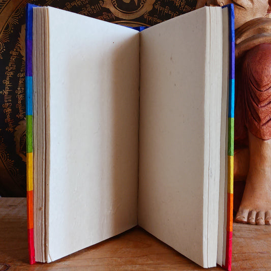 Embrace mindful creativity with this beautiful handmade Lokta notebook, featuring a soft cover adorned with a vibrant Prayer Flags print—a symbol of peace, compassion, and positive energy. Each notebook is crafted from natural, treeless Lokta paper, a sustainable material traditionally made in the Himalayas.