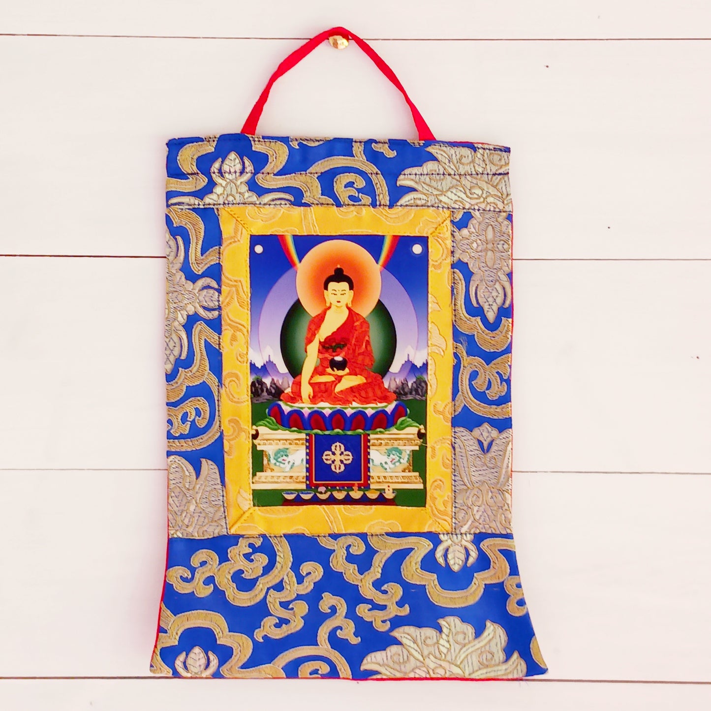 Beautiful small thangka of Shakyamuni Buddha with brocade border. A perfect spiritual art piece for meditation or home altar decoration.