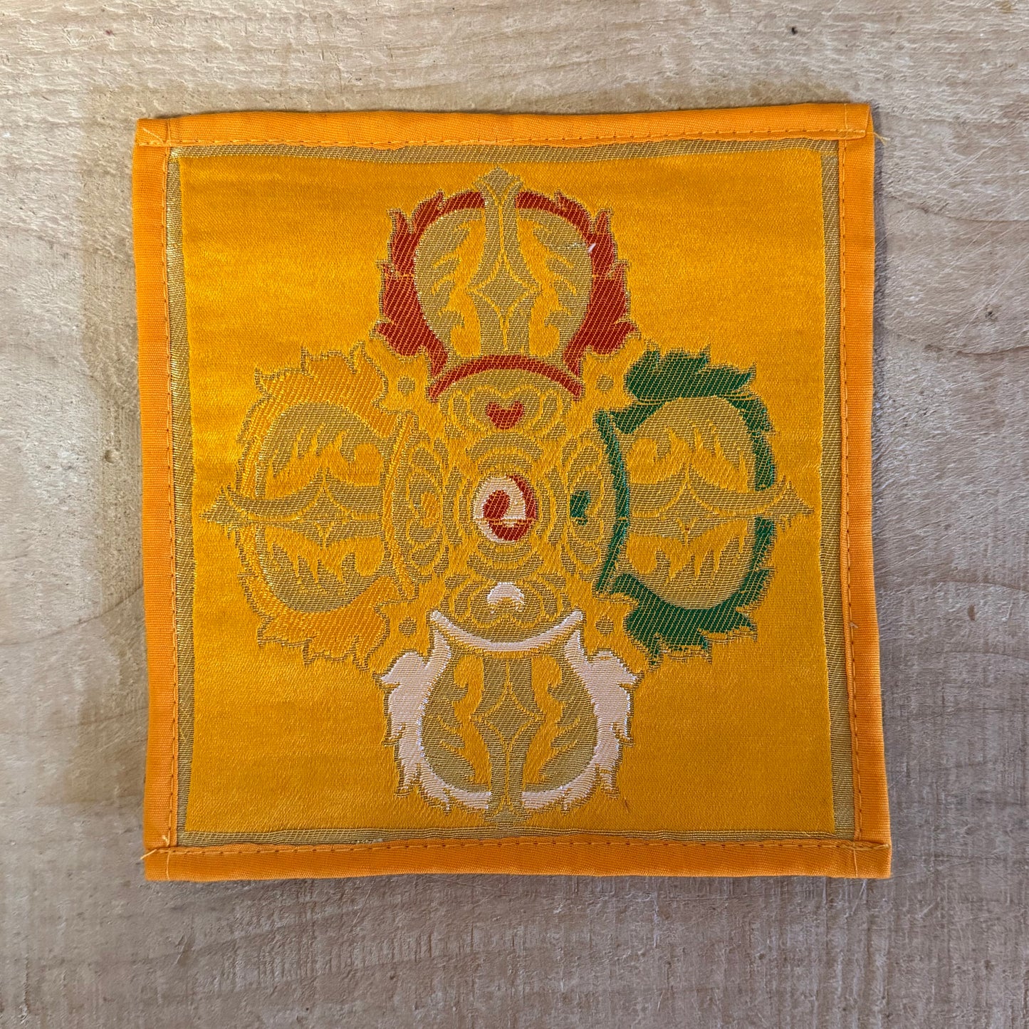 This Mini Tibetan altar cloth features a Dorje (Vajra), symbolizing the indestructible power of love, compassion, and spiritual protection. Handcrafted from thick silk brocade, this silk brocade altar mat is perfect for placement under a singing bowl, standing Dorje, or other sacred Buddhist ornaments.