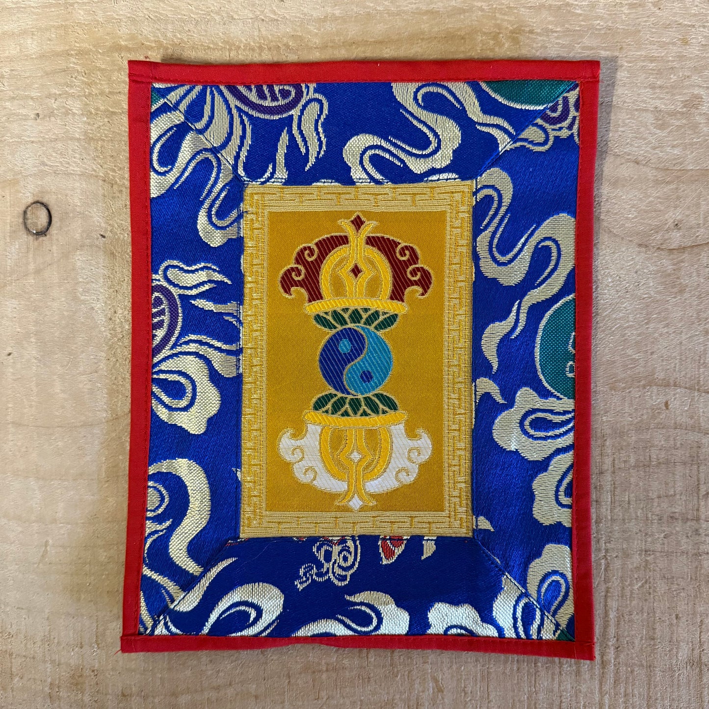 This Tibetan altar cloth features a Dorje with a Yin Yang motif, symbolizing the indestructible power of love, compassion, and balance. Crafted from thick silk brocade, this silk brocade altar mat is ideal for placement under a singing bowl, altar ornaments, or other sacred objects.