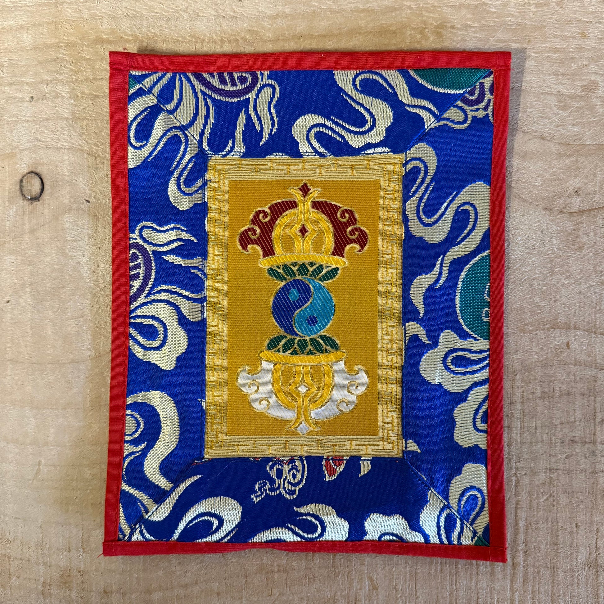 This Tibetan altar cloth features a Dorje with a Yin Yang motif, symbolizing the indestructible power of love, compassion, and balance. Crafted from thick silk brocade, this silk brocade altar mat is ideal for placement under a singing bowl, altar ornaments, or other sacred objects.