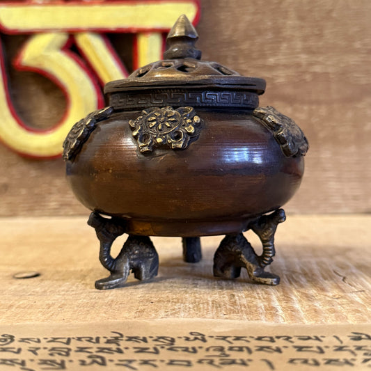 Bring sacred presence into your space with this exquisite Brass Tibetan Incense Burner – Six Symbols Standing Pot, handcrafted in India with devotion and skill. Made from solid brass, this ornate piece is adorned with six auspicious Tibetan symbols, each representing a divine blessing: good fortune, health, prosperity, longevity, peace, and harmony.

Resting upon traditional Tibetan dragon feet, this burner embodies both grace and strength — the dragon, a guardian of spiritual treasures, offering protection