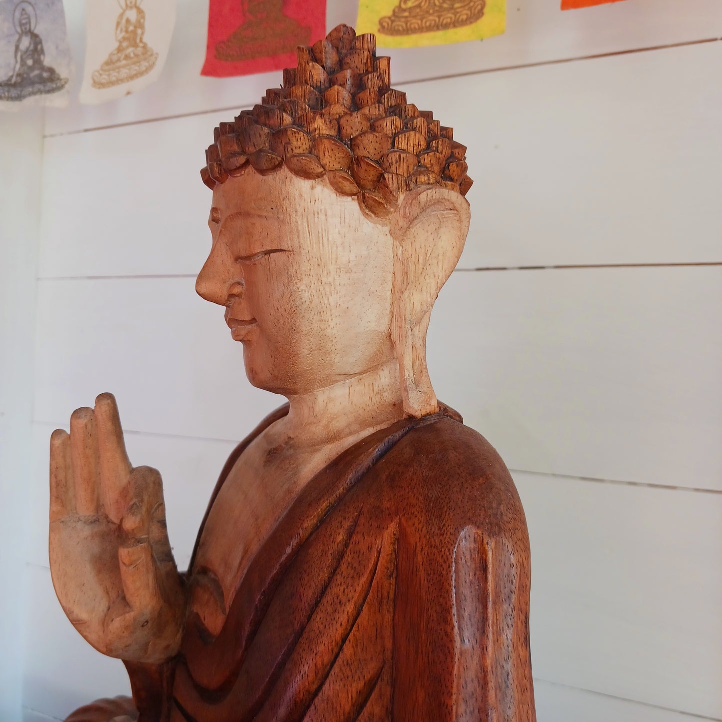 his beautifully serene Teaching Buddha statue has been carved by hand from Suar wood which is a fast-growing species, allowing for sustainable cultivation. The Albizia Saman species of tree is widespread, abundant, and in no danger of extinction. The Buddha is carved using tools in the traditional Balinese way, bringing each detail to life in a three-dimensional work of art. Hand carved Buddha statues can take up to weeks to carve.  The Buddha is in the Teaching Pose which signifies wisdom, understanding an