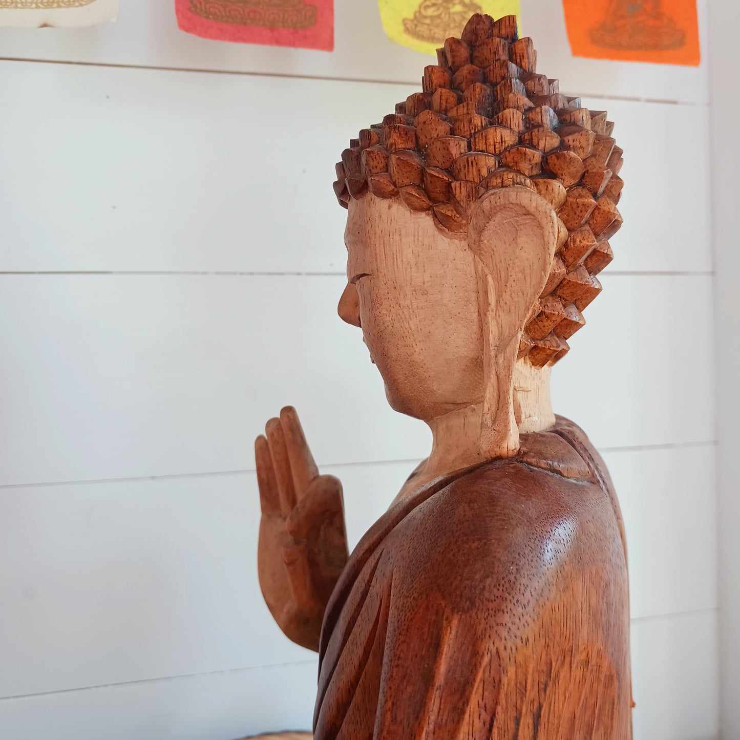 his beautifully serene Teaching Buddha statue has been carved by hand from Suar wood which is a fast-growing species, allowing for sustainable cultivation. The Albizia Saman species of tree is widespread, abundant, and in no danger of extinction. The Buddha is carved using tools in the traditional Balinese way, bringing each detail to life in a three-dimensional work of art. Hand carved Buddha statues can take up to weeks to carve.  The Buddha is in the Teaching Pose which signifies wisdom, understanding an