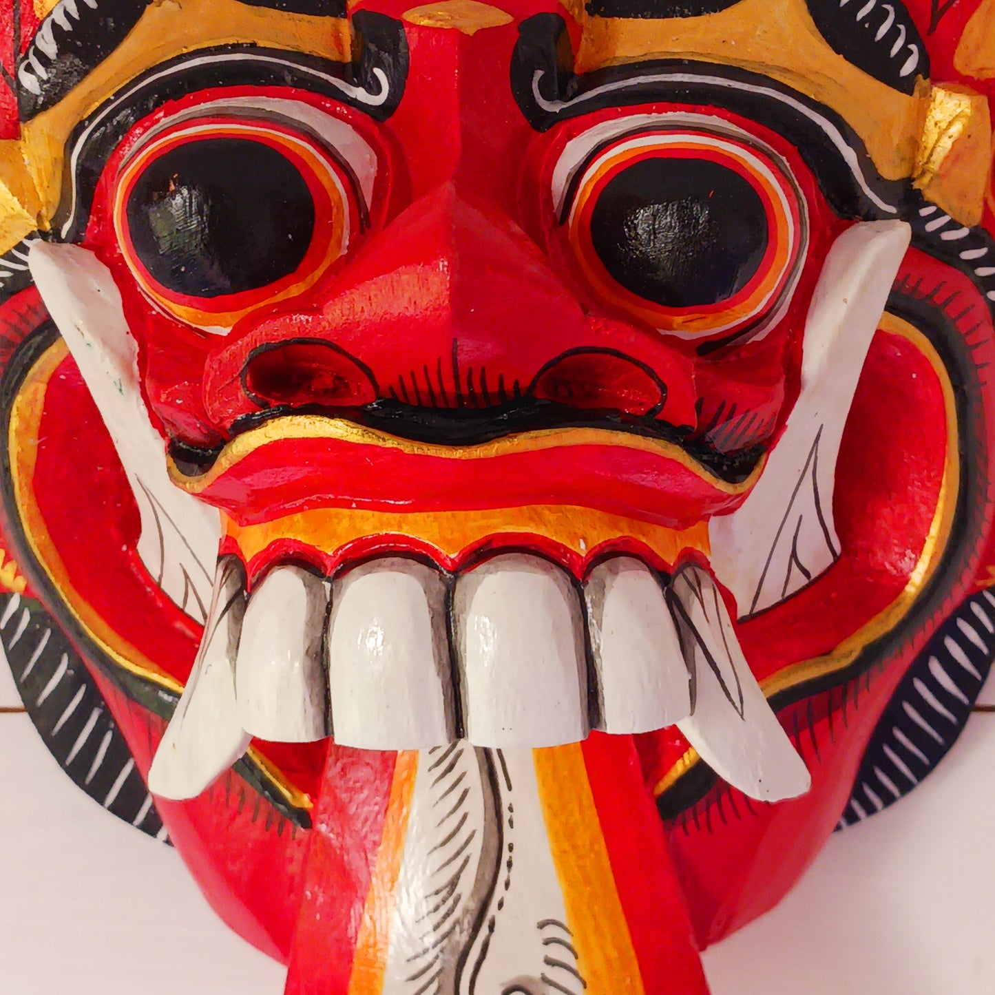 The Rangda mask is a traditional Balinese mask seen in the Barong dance. The mask depicts Rangda who is the queen of witches and represents the personification of all evil. She is depicted with a grotesque visage with protruding fangs, wild goggle eyes and long tongue. In the dance, she leads a terrifying army of witches against the forces of good and their leader, Barong.