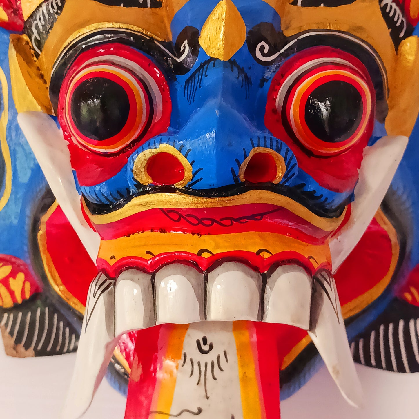 The Rangda mask is a traditional Balinese mask seen in the Barong dance. The mask depicts Rangda who is the queen of witches and represents the personification of all evil. She is depicted with a grotesque visage with protruding fangs, wild goggle eyes and long tongue. In the dance, she leads a terrifying army of witches against the forces of good and their leader, Barong.