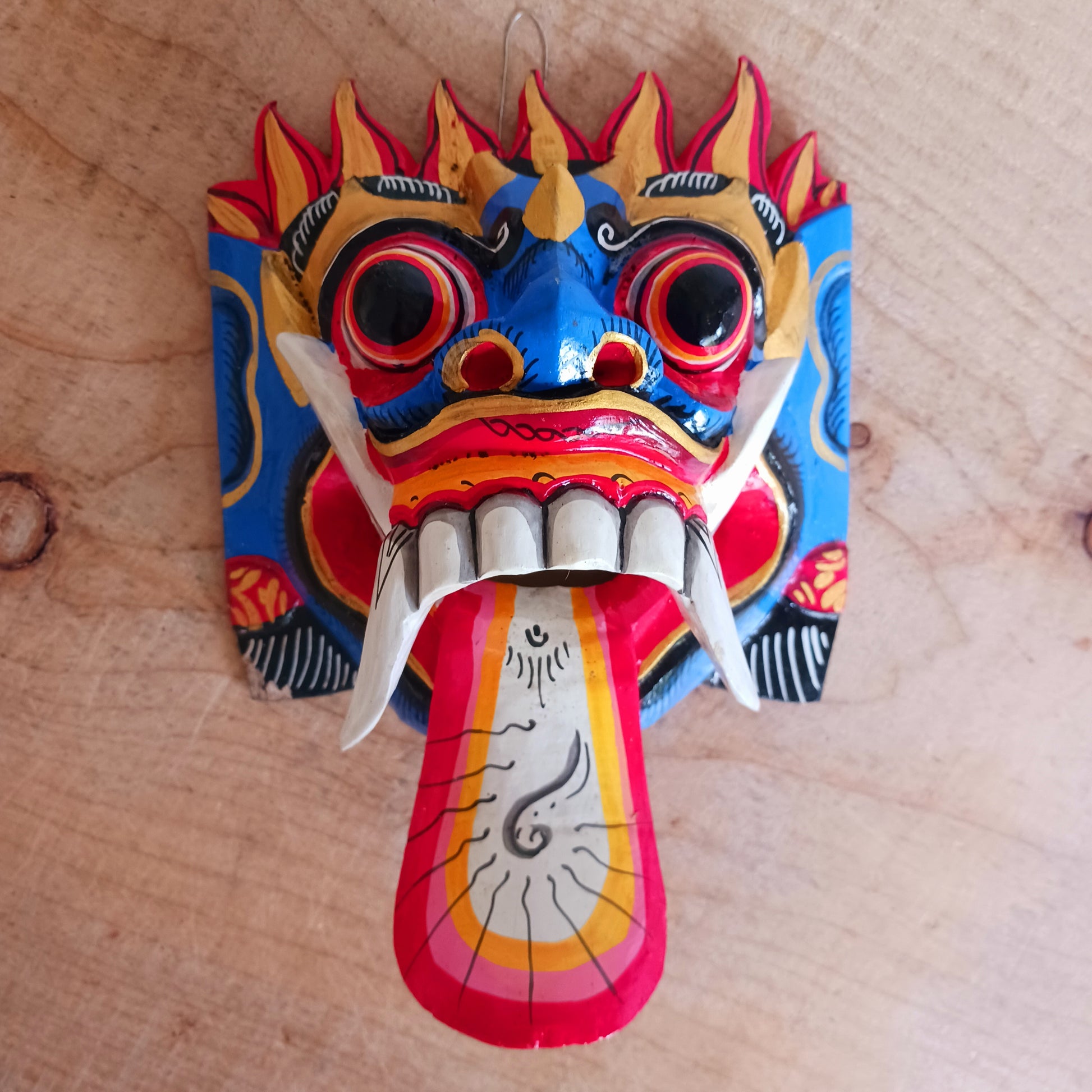 The Rangda mask is a traditional Balinese mask seen in the Barong dance. The mask depicts Rangda who is the queen of witches and represents the personification of all evil. She is depicted with a grotesque visage with protruding fangs, wild goggle eyes and long tongue. In the dance, she leads a terrifying army of witches against the forces of good and their leader, Barong.