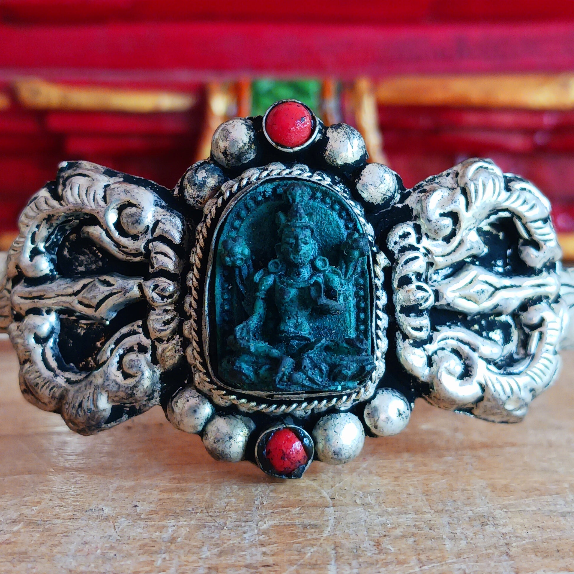 This handmade Tibetan bracelet has a turquoise Tibetan deity on the front. It has Vajra (Dorje) as a center piece.