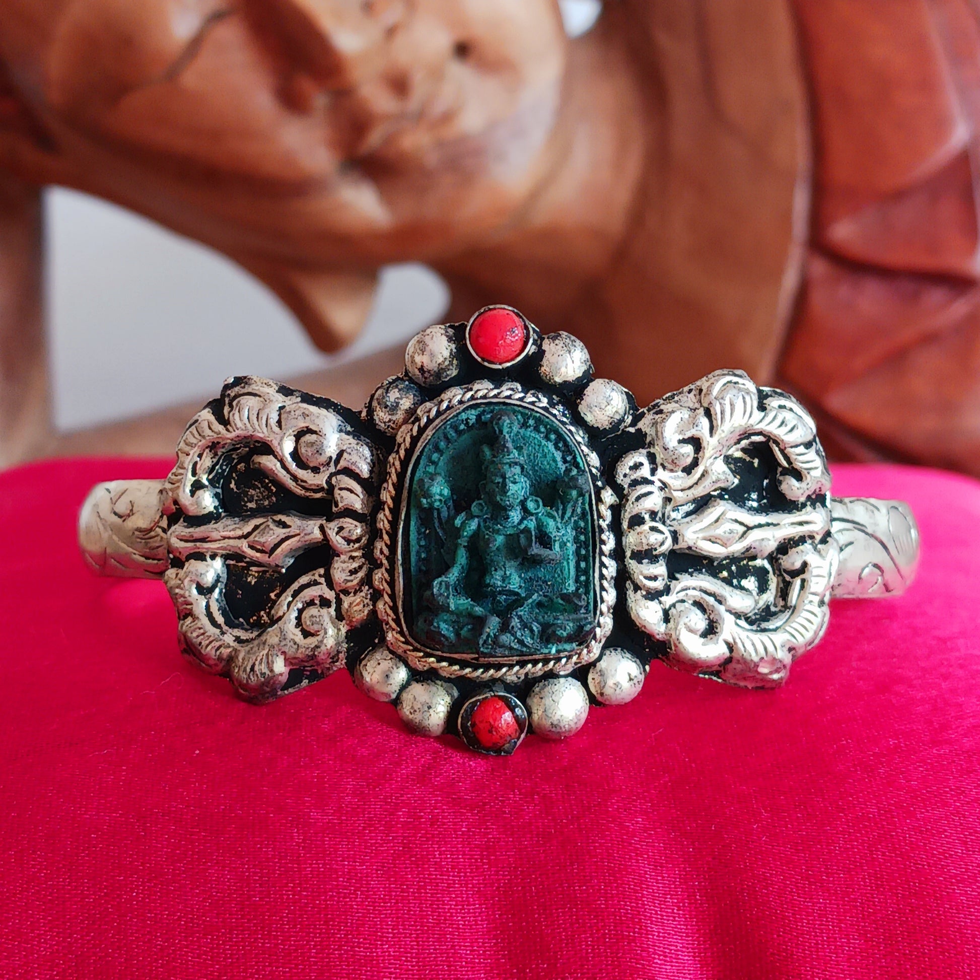 This handmade Tibetan bracelet has a turquoise Tibetan deity on the front. It has Vajra (Dorje) as a center piece.