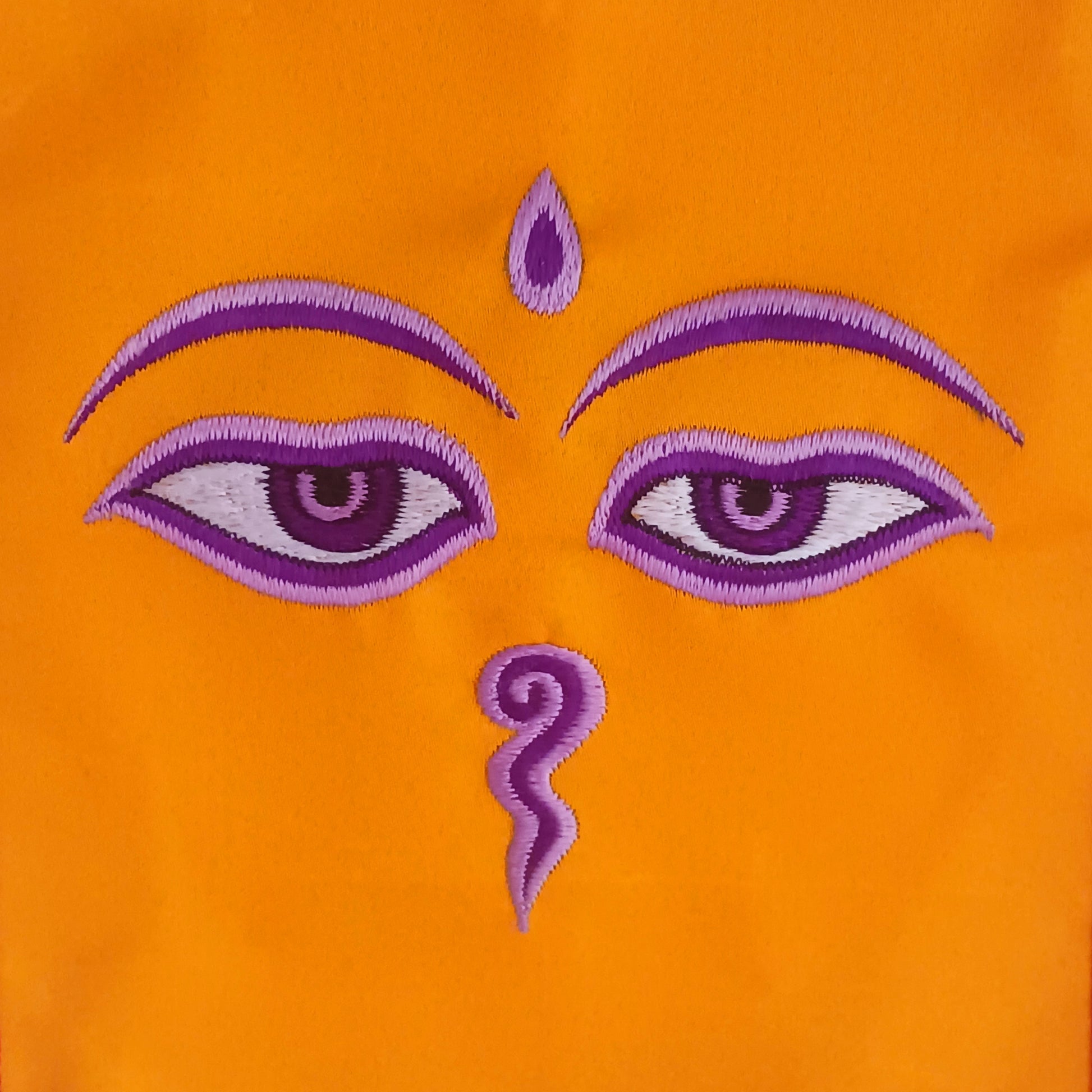 Representing an all-seeing, omniscient Buddha, these embroidered banners depict two eyes in the four cardinal directions, and the Nepali character for the number 1 sits between them like a question mark. This symbolizes the unity of all things and the one path to enlightenment.