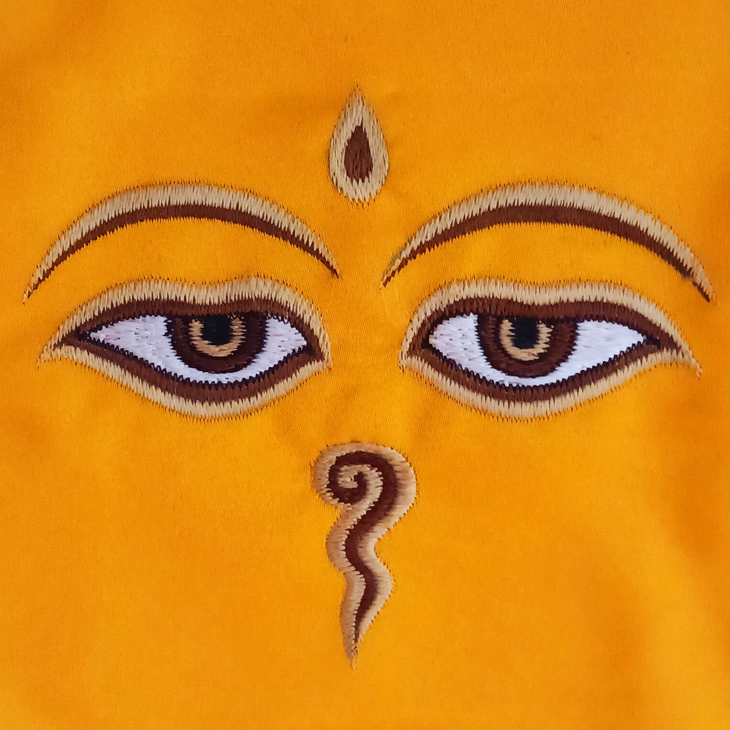 Representing an all-seeing, omniscient Buddha, these embroidered banners depict two eyes in the four cardinal directions, and the Nepali character for the number 1 sits between them like a question mark. This symbolizes the unity of all things and the one path to enlightenment.