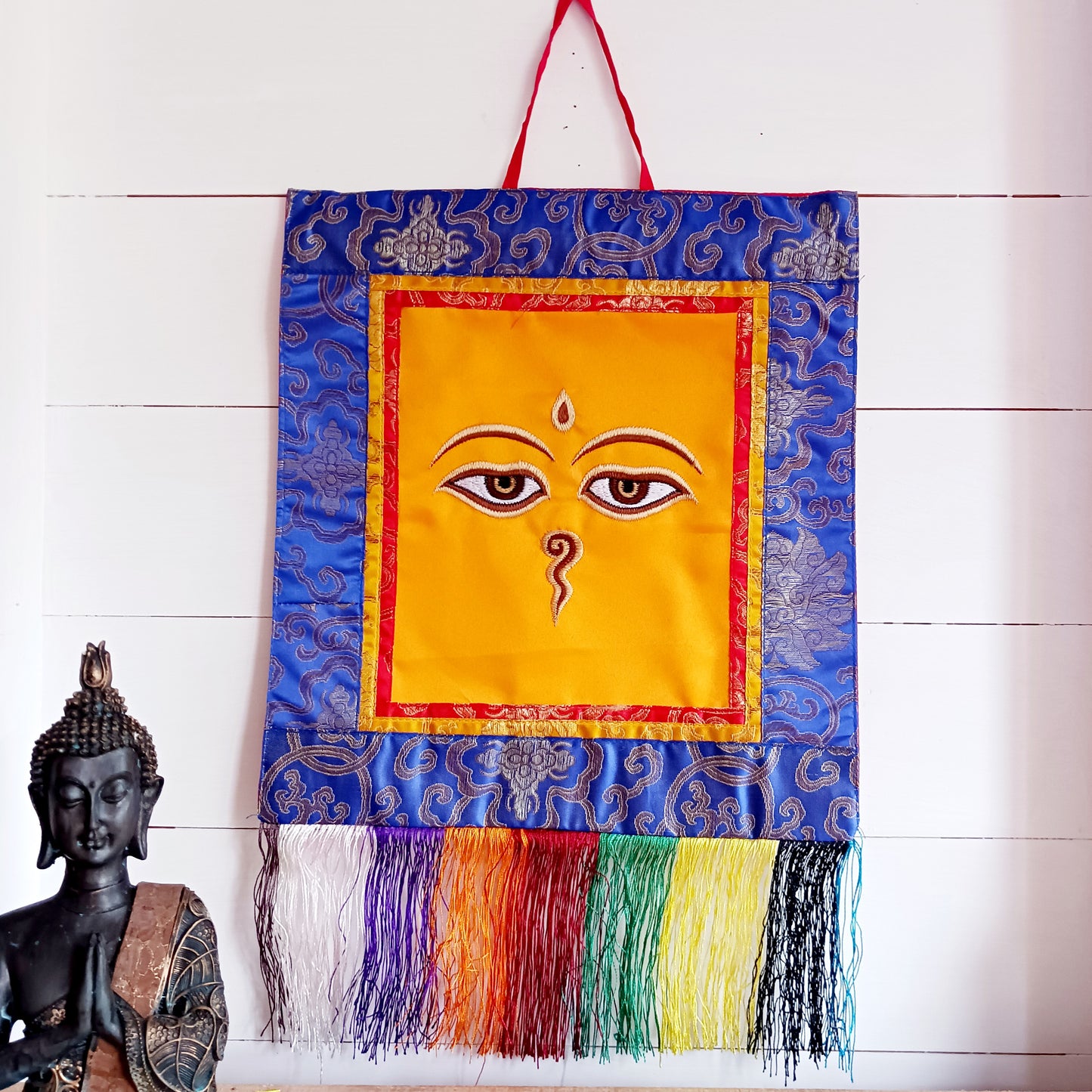 Representing an all-seeing, omniscient Buddha, these embroidered banners depict two eyes in the four cardinal directions, and the Nepali character for the number 1 sits between them like a question mark. This symbolizes the unity of all things and the one path to enlightenment.