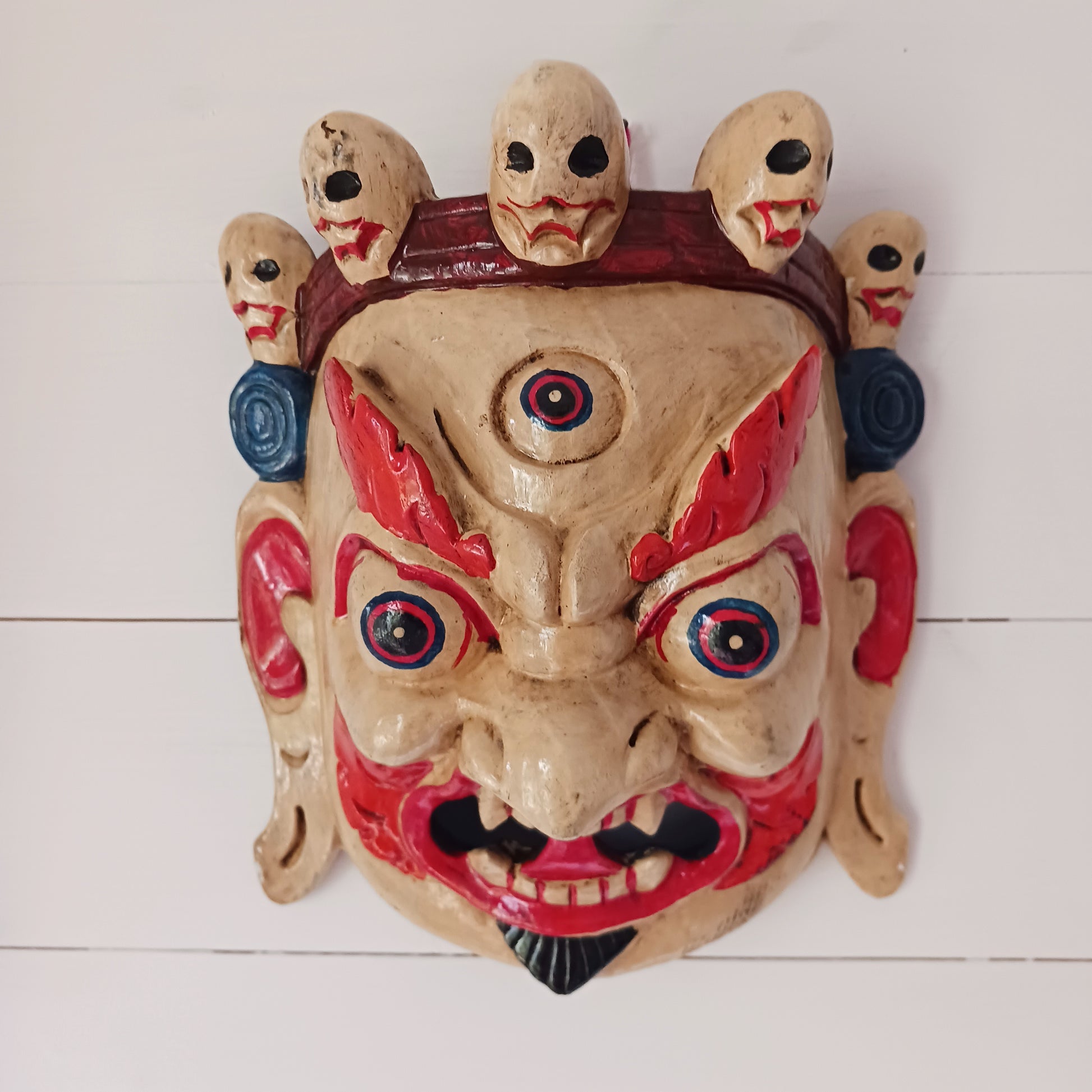 This Mahakala mask is a beautifully handcrafted wooden piece featuring intricate details and a unique design. Inspired by the powerful deity, this mask is a representation of strength, protection, and courage. 