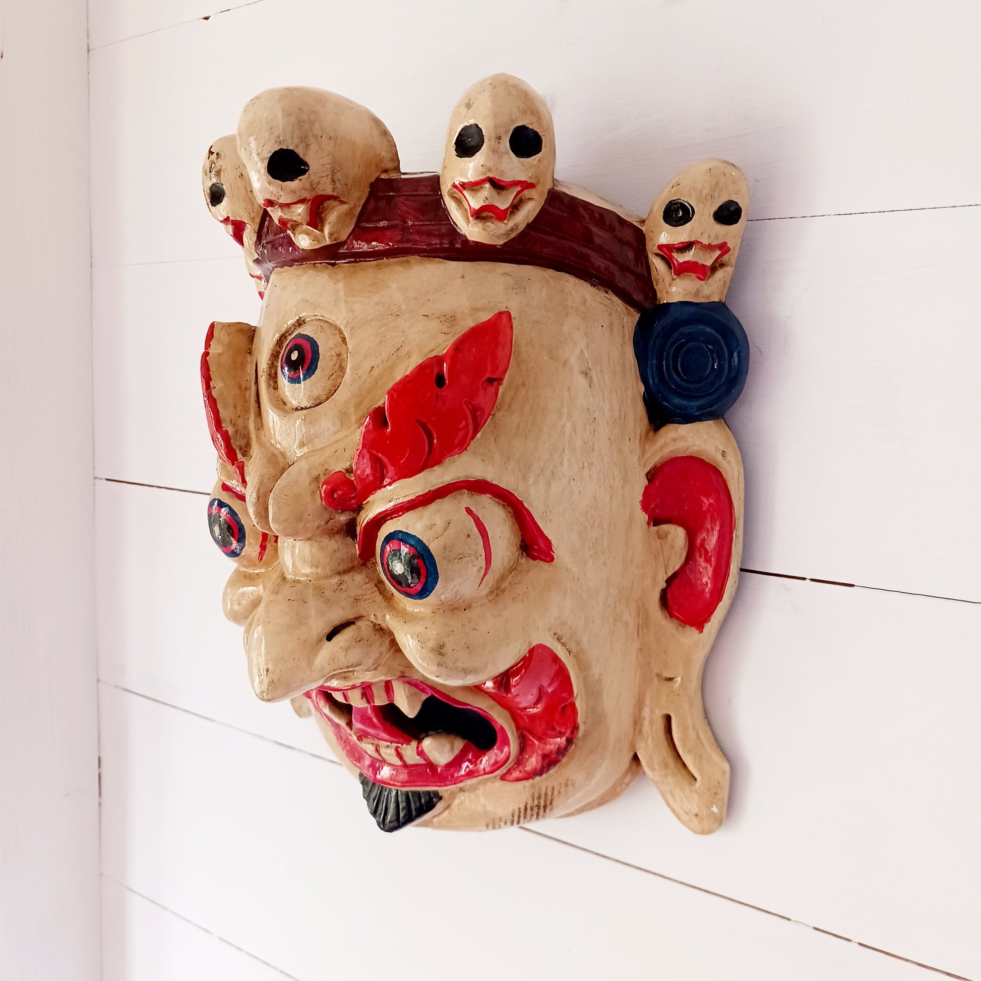 This Mahakala mask is a beautifully handcrafted wooden piece featuring intricate details and a unique design. Inspired by the powerful deity, this mask is a representation of strength, protection, and courage. 