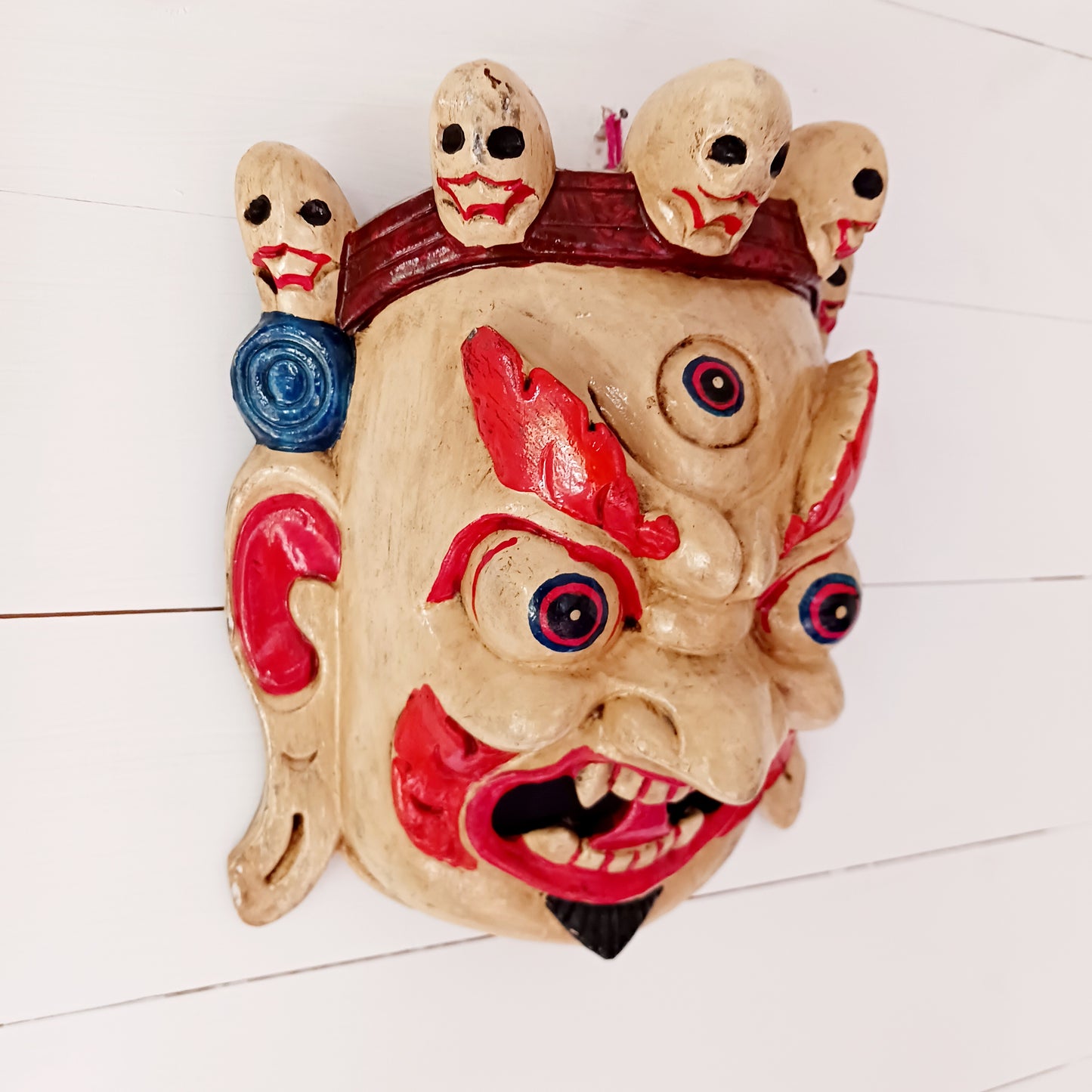 This Mahakala mask is a beautifully handcrafted wooden piece featuring intricate details and a unique design. Inspired by the powerful deity, this mask is a representation of strength, protection, and courage. 