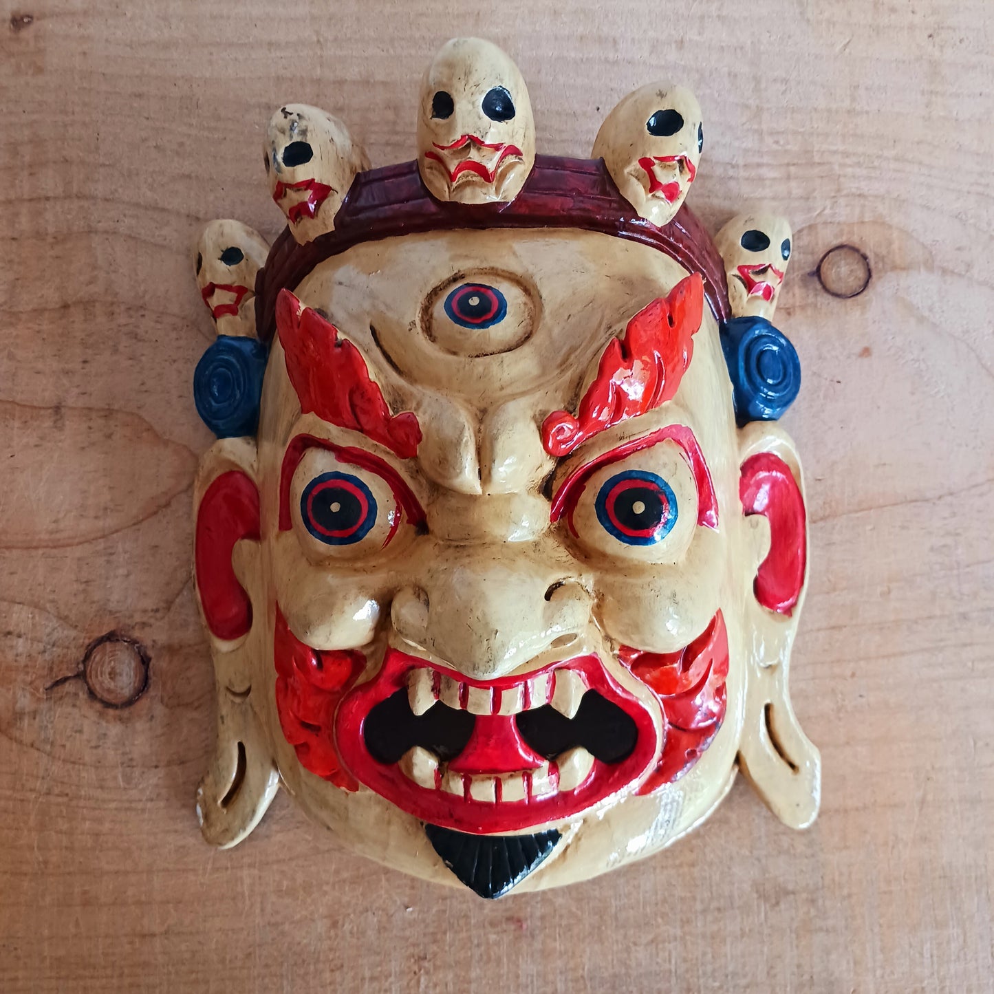 This Mahakala mask is a beautifully handcrafted wooden piece featuring intricate details and a unique design. Inspired by the powerful deity, this mask is a representation of strength, protection, and courage. 