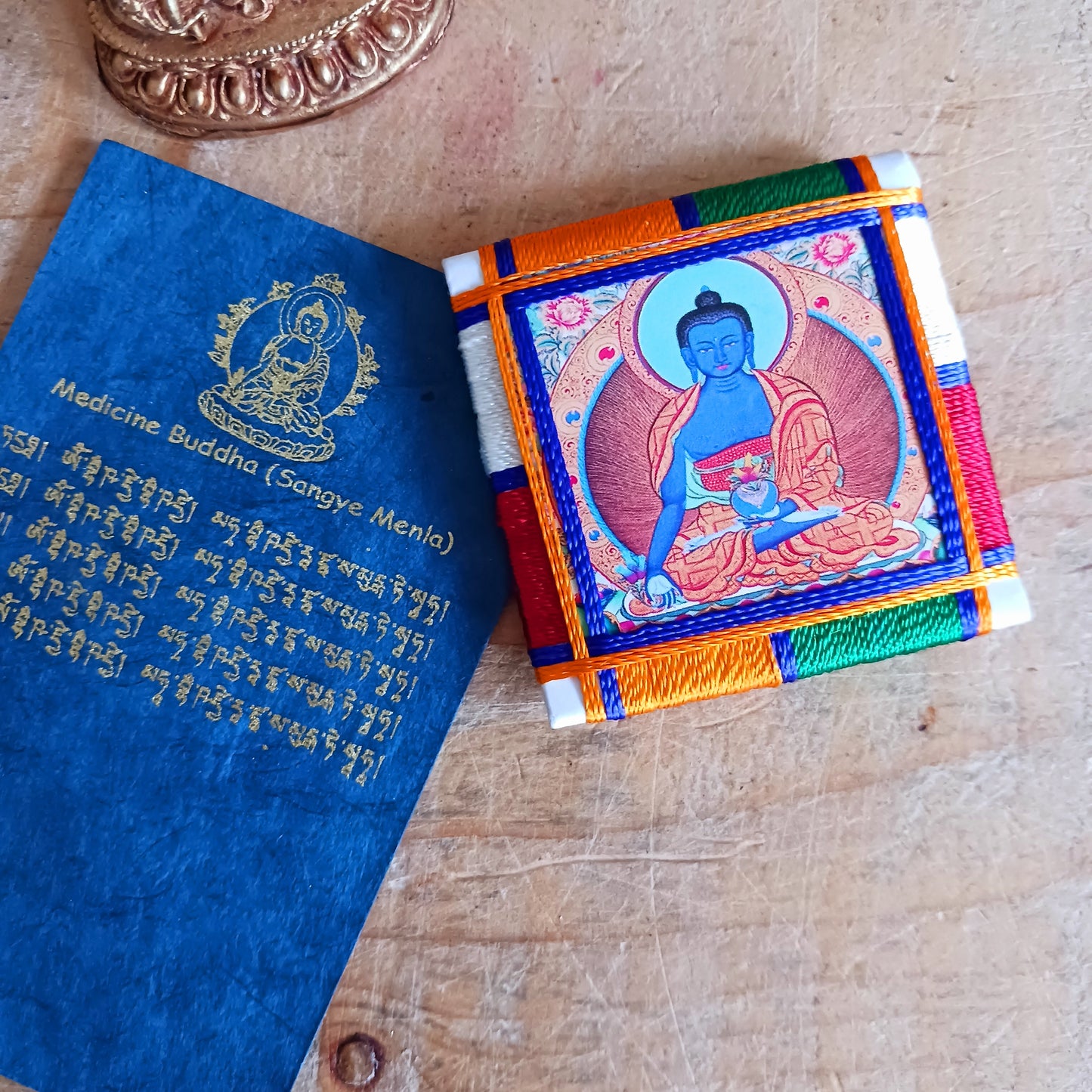 The healing embrace of the Medicine Buddha Protection Amulet, a sacred creation handmade in Nepal.