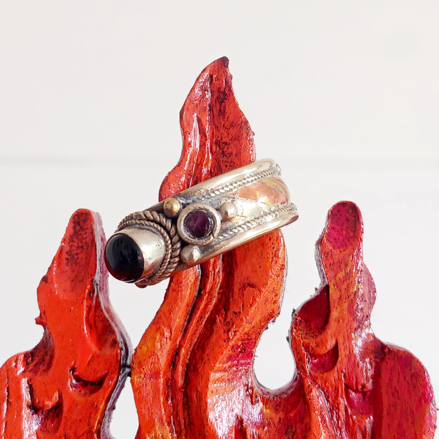 Nepalese white metal finger ring decorated with a black tourmaline centre stone and two tiny red coral stones either side.