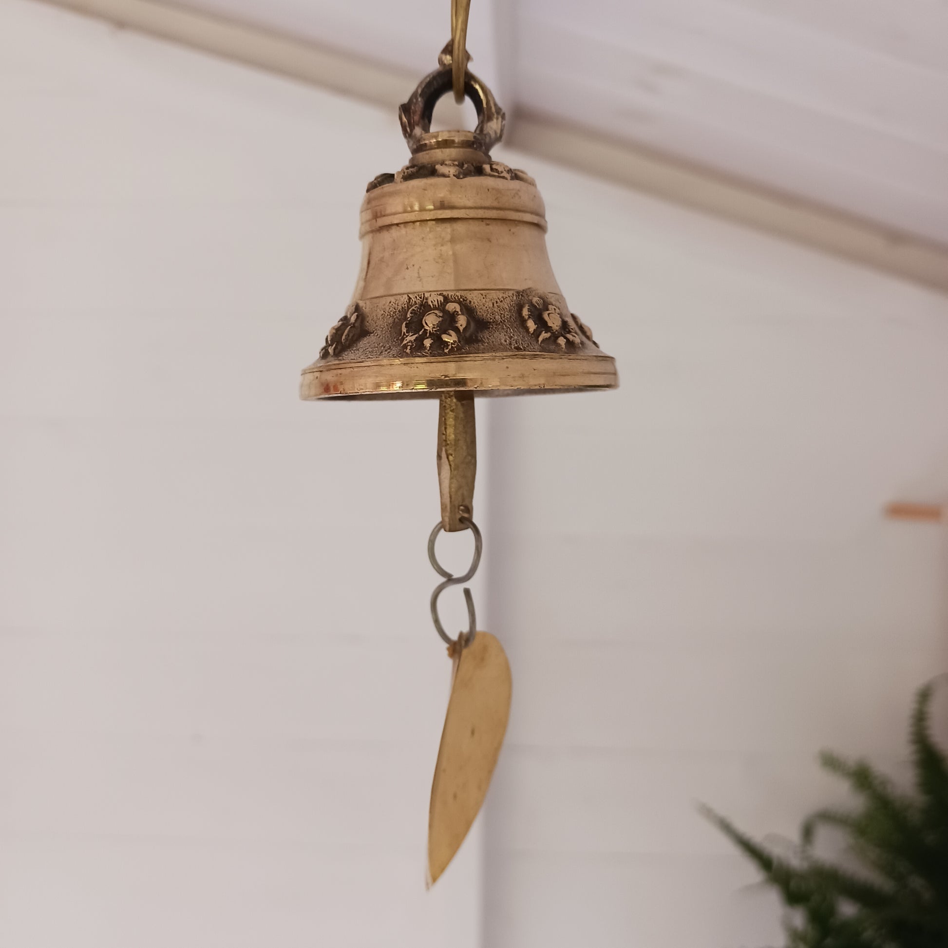 This hanging bell is made of brass in traditional Temple bell design, decorated with auspicious symbols and a brass bodhi leaf.