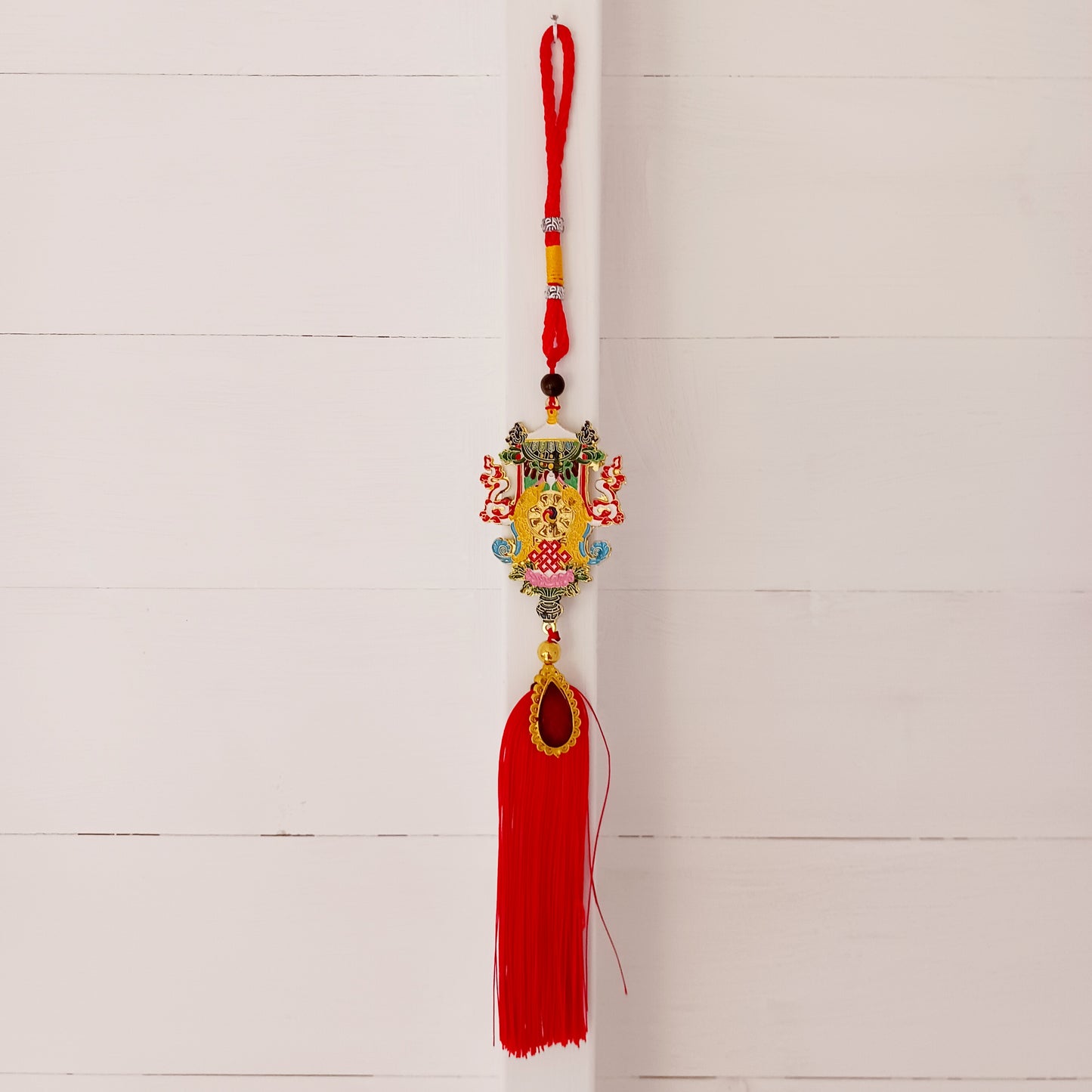 This beautifully decorated Auspicious Symbols Tibetan Buddhist amulet can be used as a wall hanging or car hanging decoration.