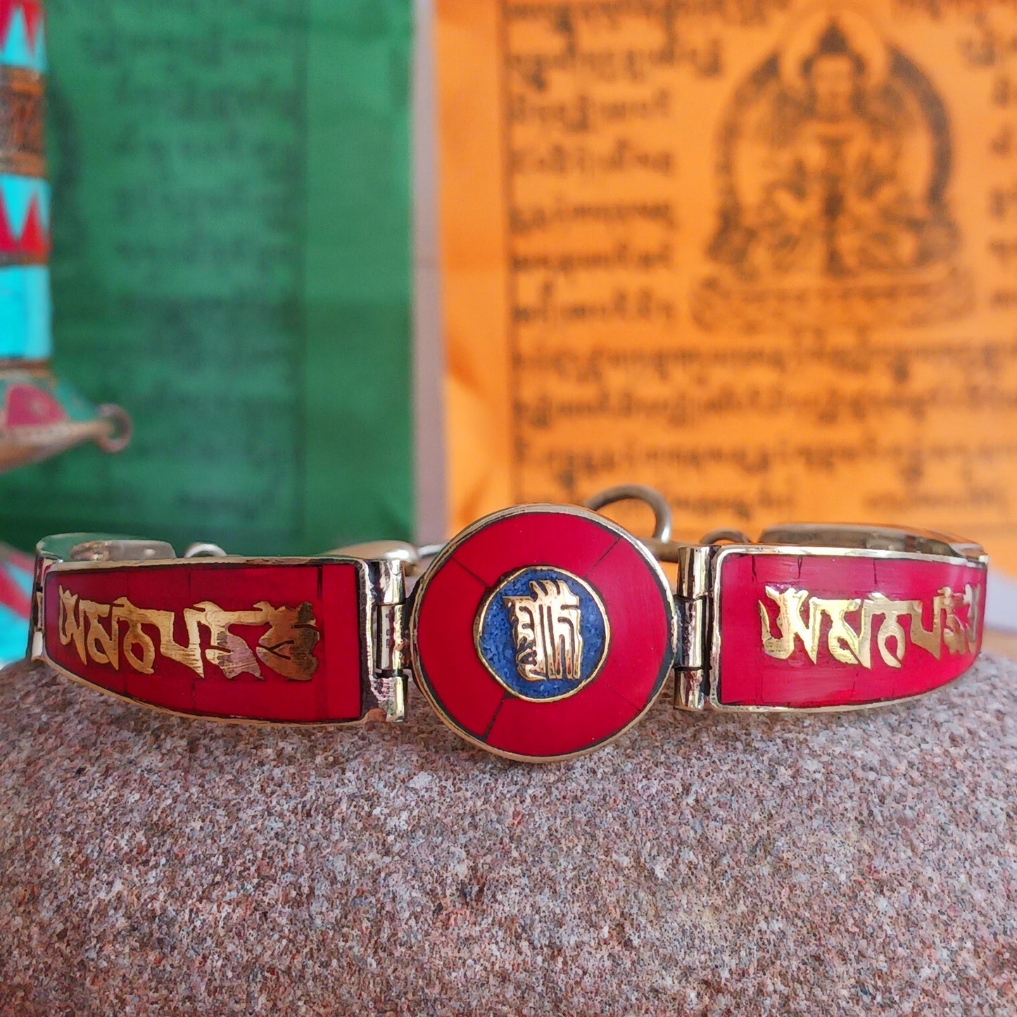 This Tibetan Mantra bracelet is made from brass with inlaid coral and lapis chips.