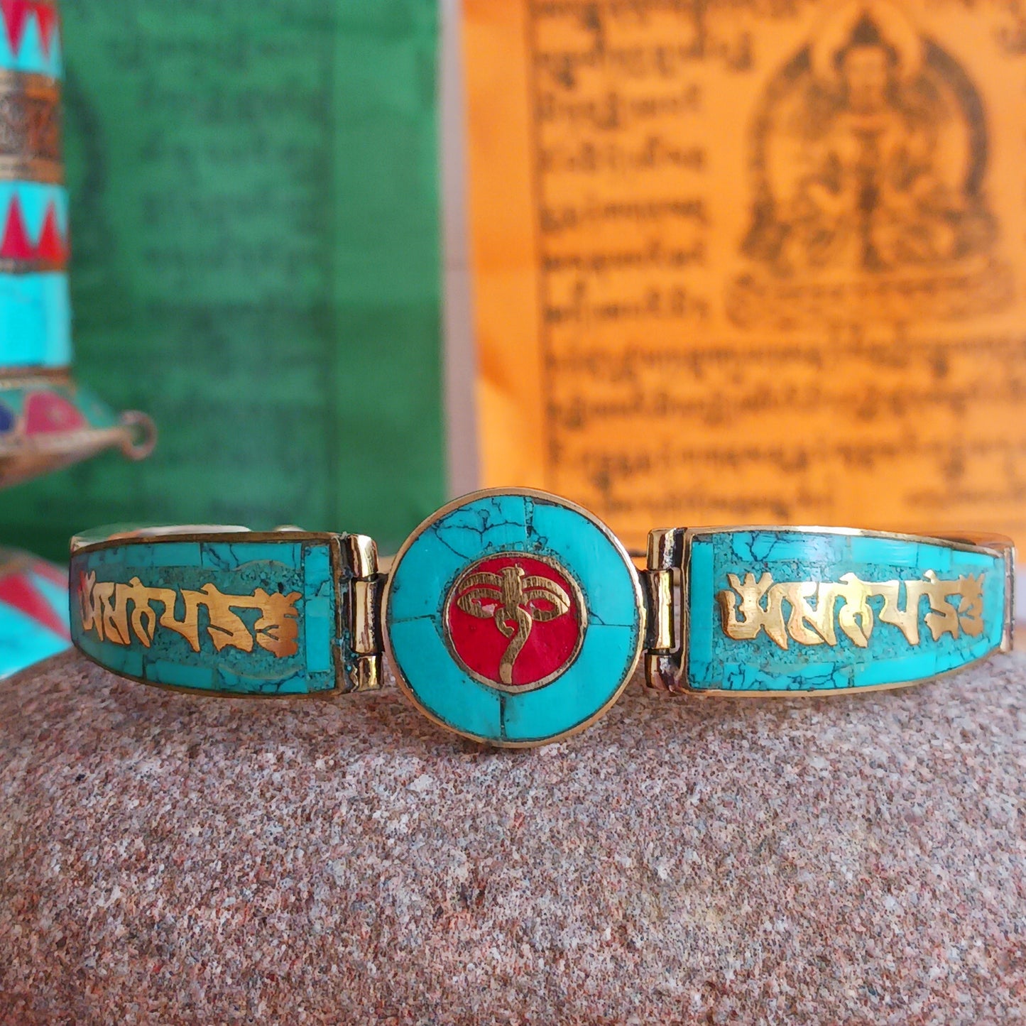 This Tibetan Mantra bracelets are made from brass with inlaid turquoise and coral chips.