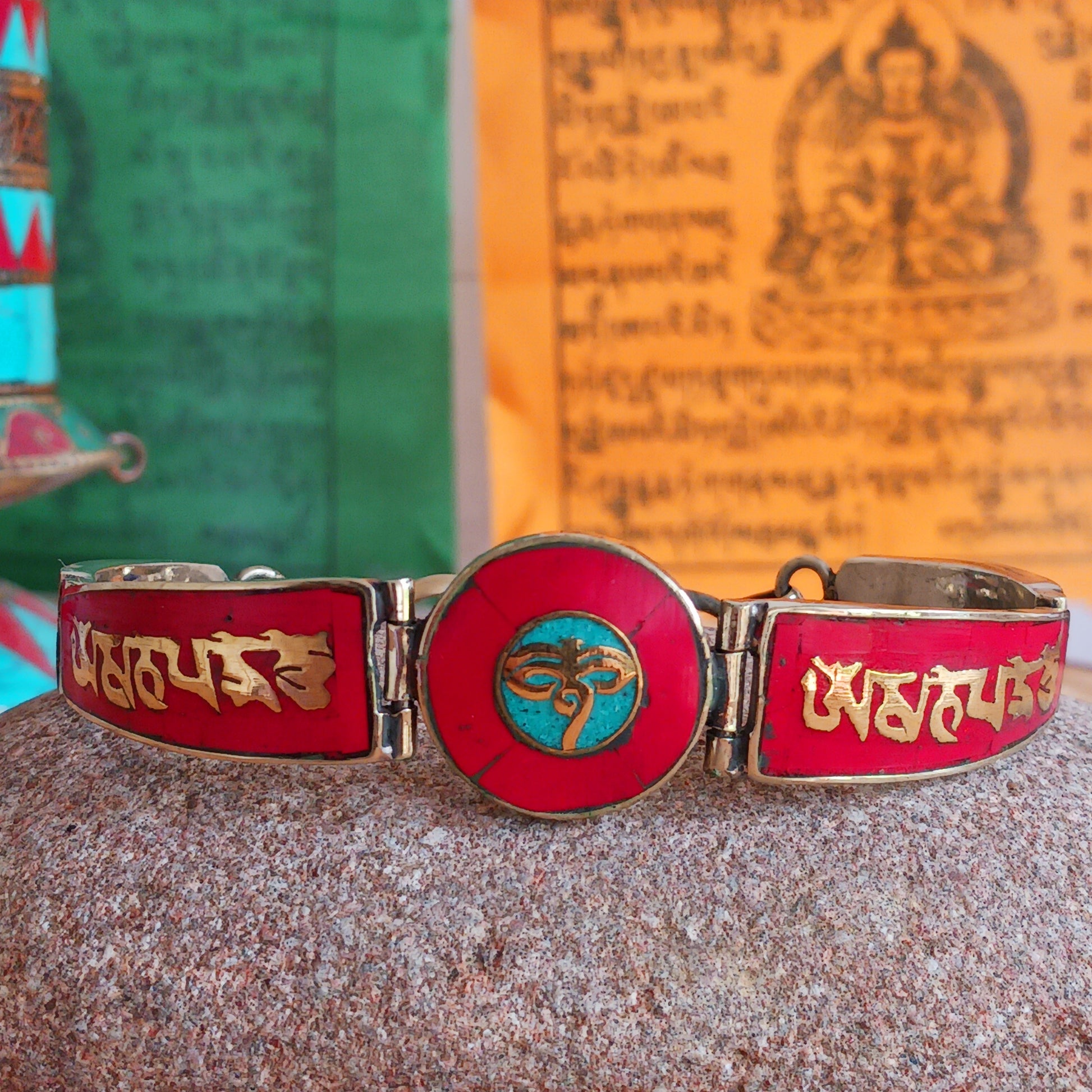 This Tibetan Mantra bracelet is made from brass with inlaid coral and turquoise chips.