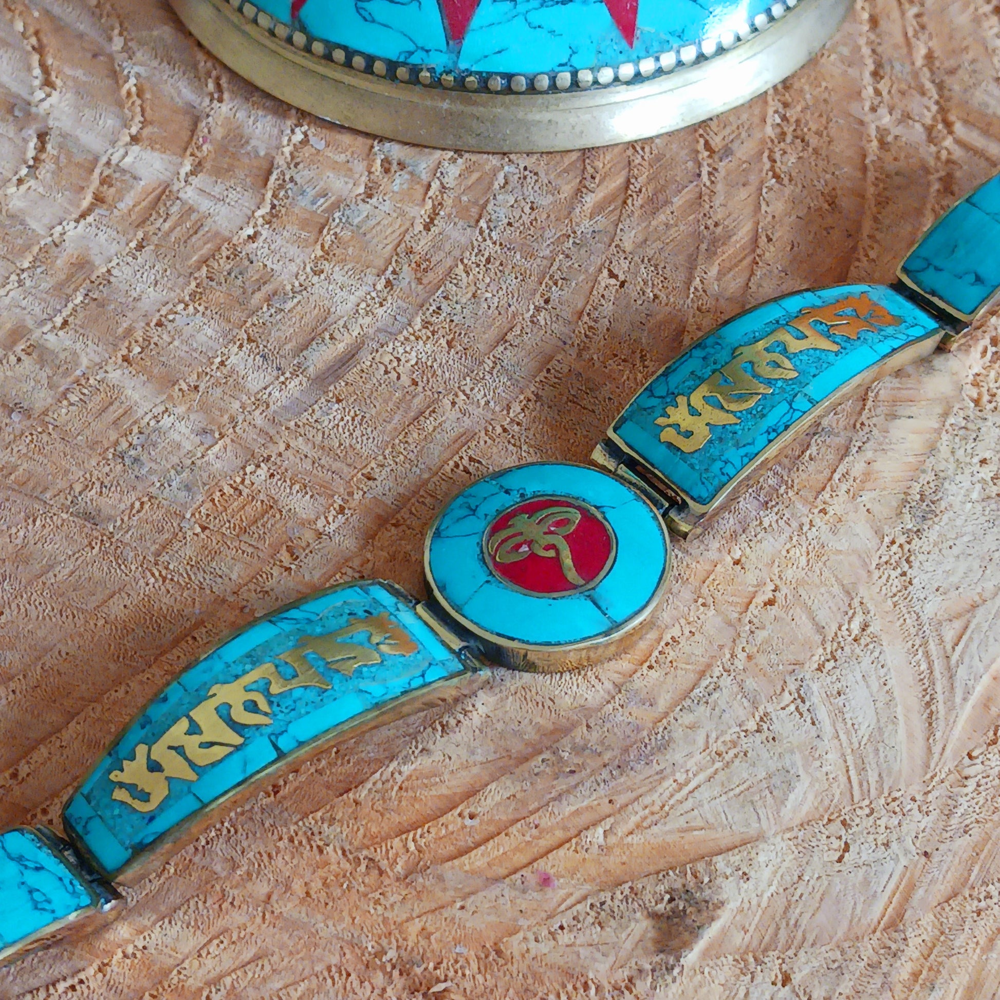 This Tibetan Mantra bracelets are made from brass with inlaid turquoise and coral chips.