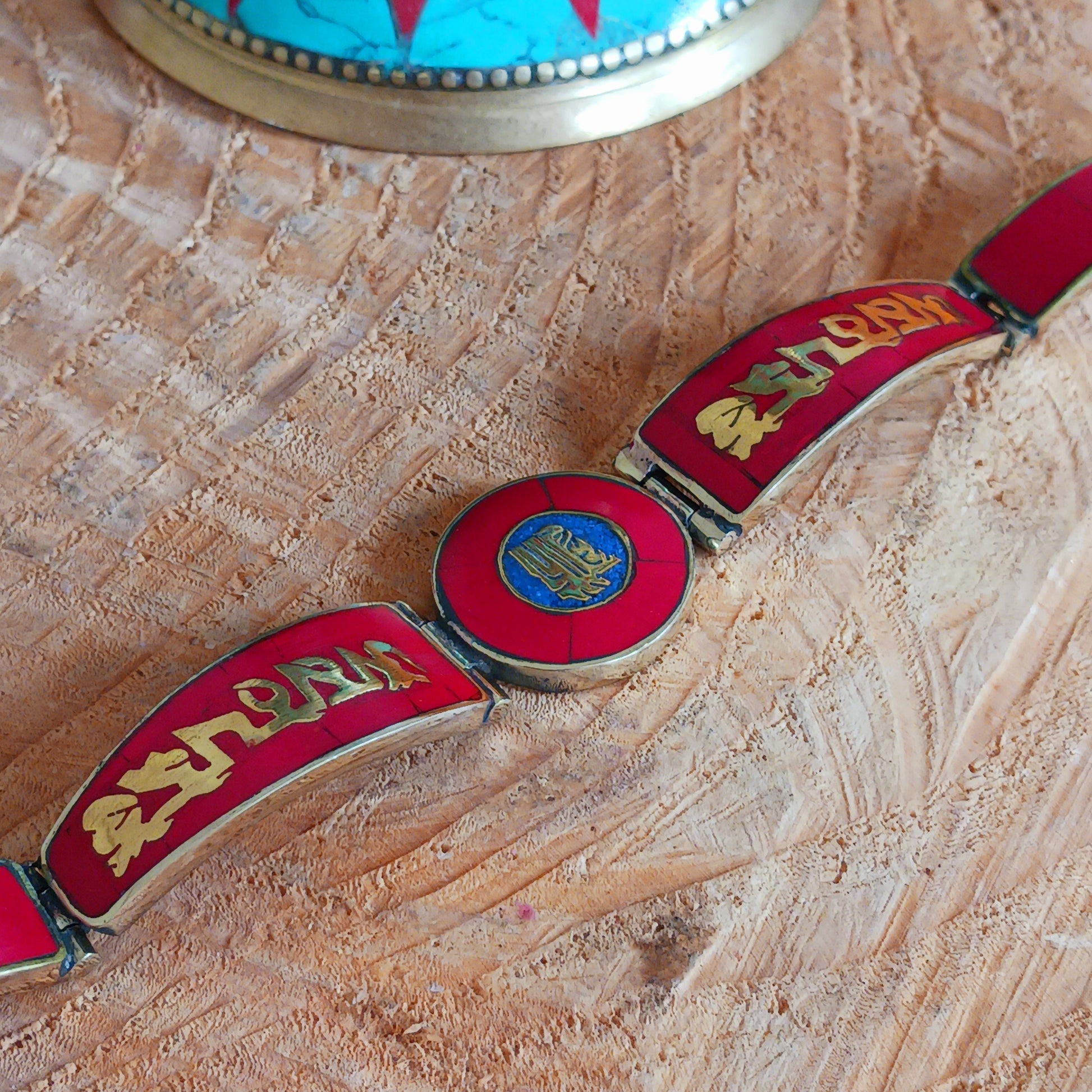 This Tibetan Mantra bracelet is made from brass with inlaid coral and lapis chips.