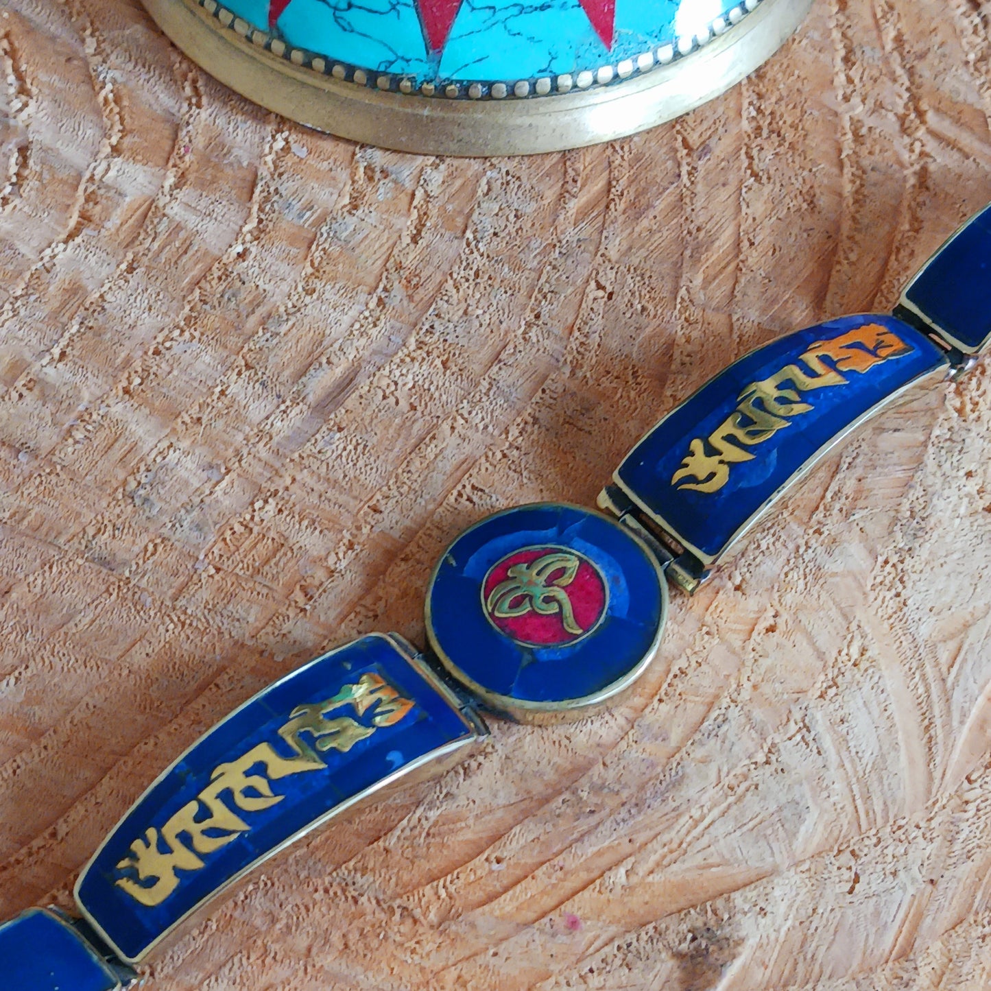 This Tibetan Mantra bracelets are made from brass with inlaid lapis and coral chips.