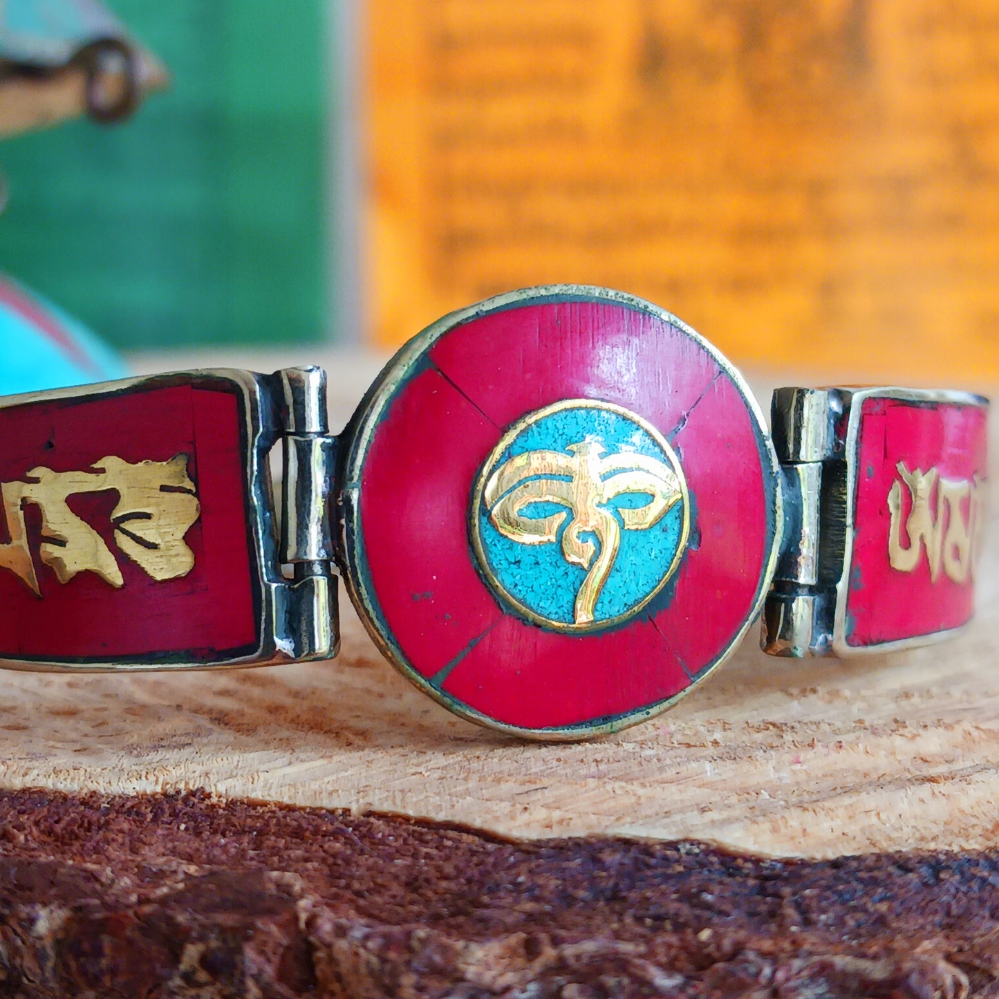 This Tibetan Mantra bracelet is made from brass with inlaid coral and turquoise chips.