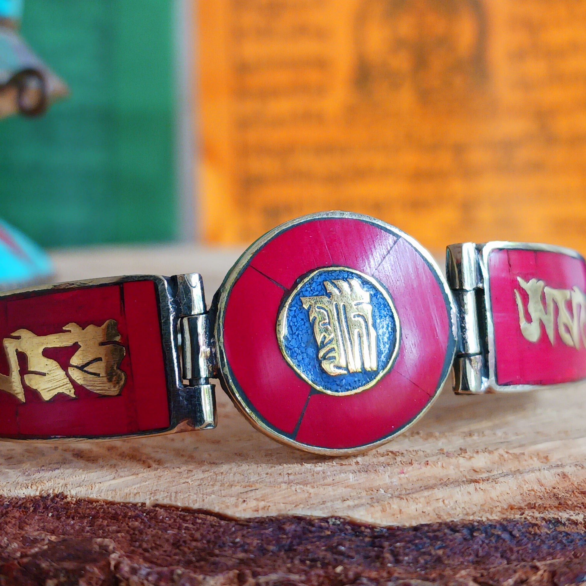 This Tibetan Mantra bracelet is made from brass with inlaid coral and lapis chips.