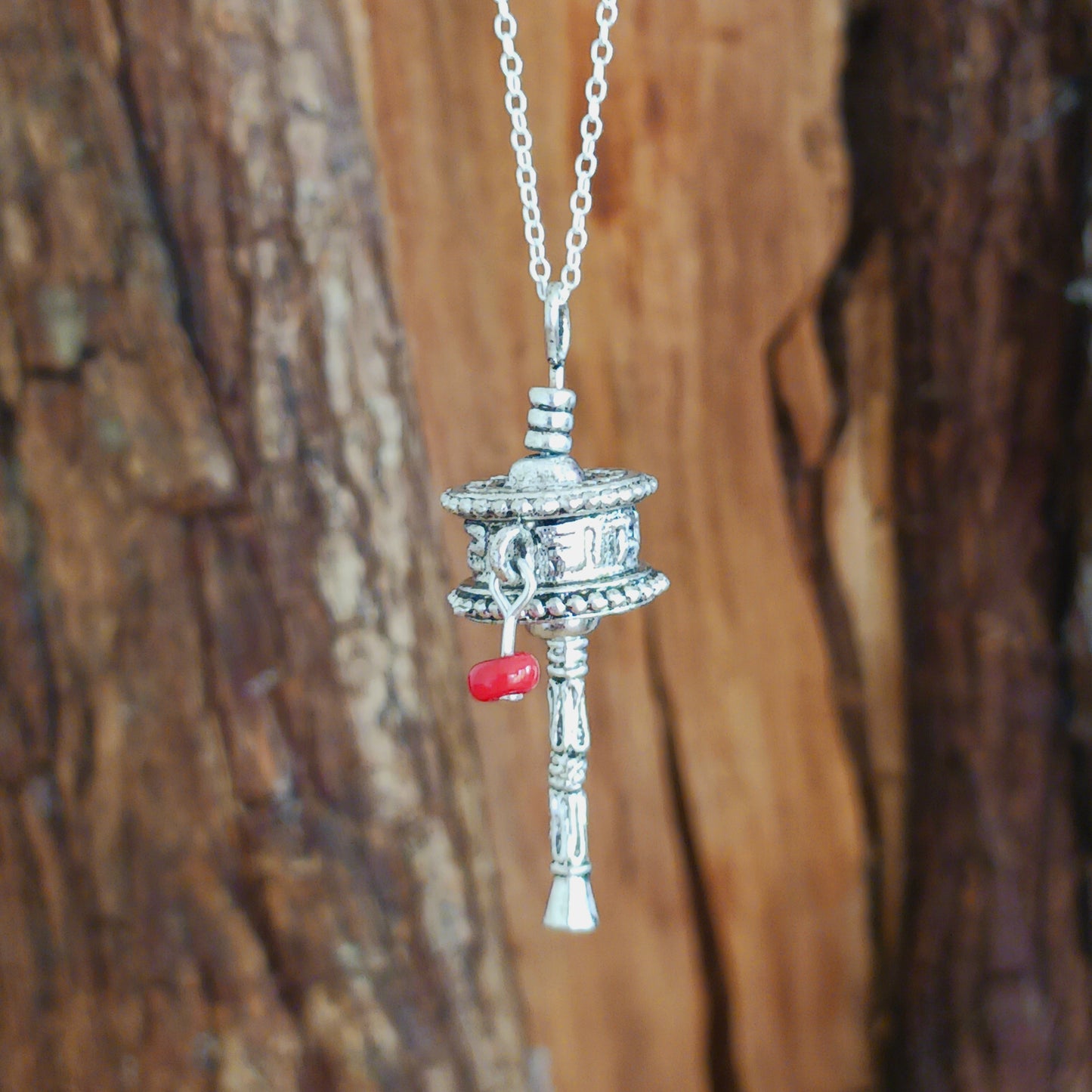 This sterling silver prayer wheel pendant has a Tibetan mantra engraved around the wheel.