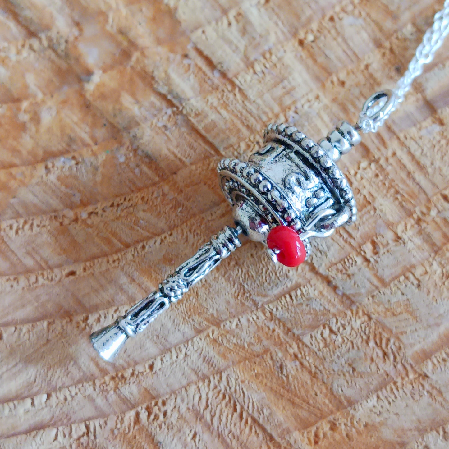 This sterling silver prayer wheel pendant has a Tibetan mantra engraved around the wheel.