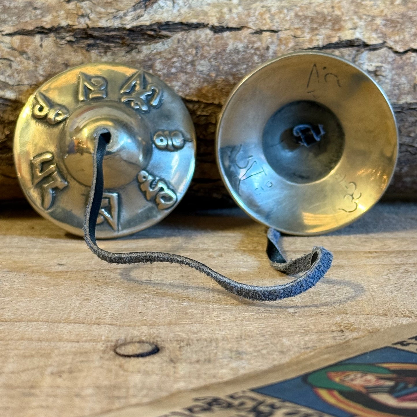 Tingsa or Tingsha are two small cymbals that are used by Buddhists during offerings, prayer and meditation. The cymbals are generally joined together by a leather strap and produce a clear, high pitched ringing tone when struck together.