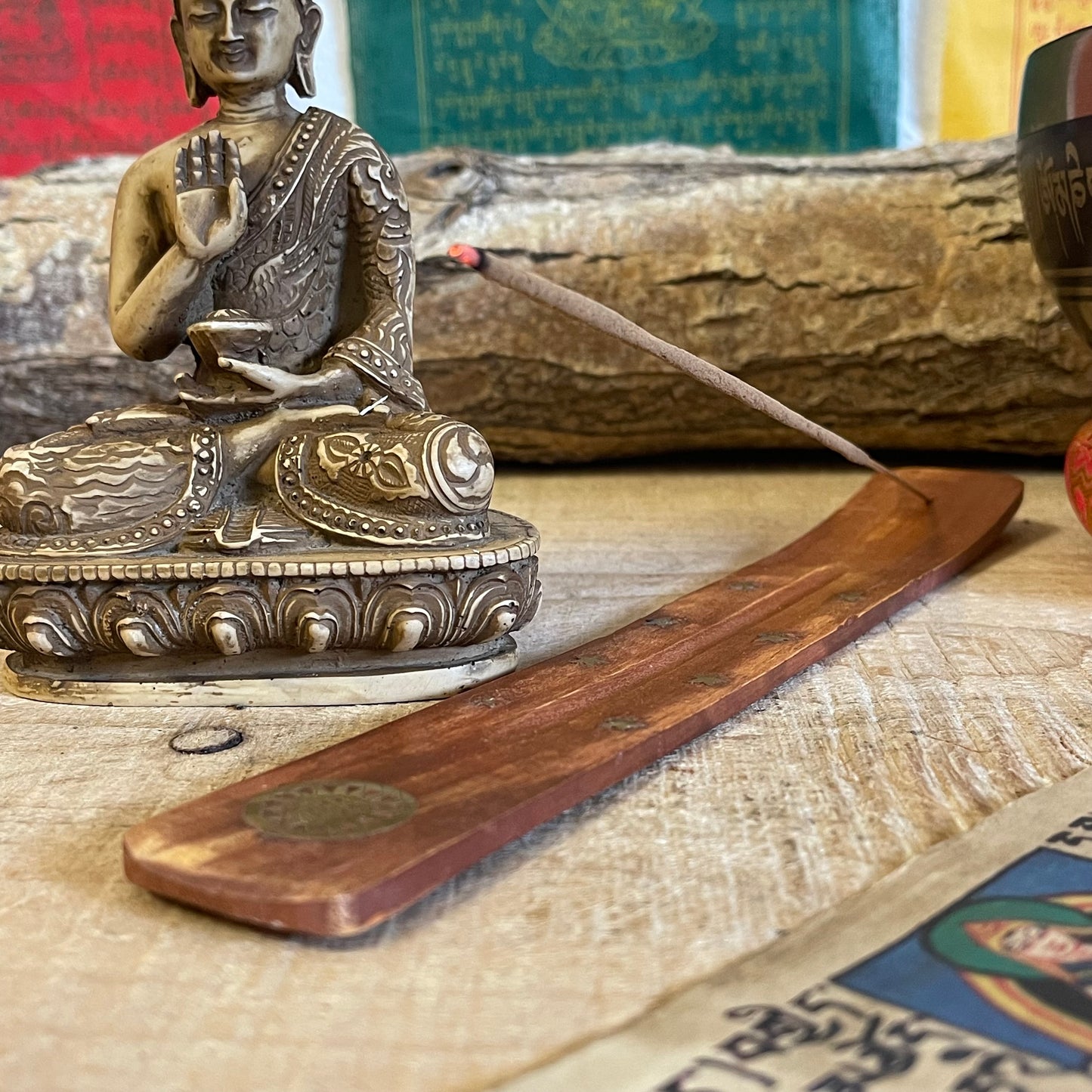 This wooden incense holder is a beautiful ash catcher with a celestial design, ideal for enhancing the atmosphere of any space. Crafted from natural wood and inlaid with a brass moon and stars pattern, this piece is both functional and decorative. Its slightly curved design holds stick incense securely while catching falling ash, keeping your surroundings clean.