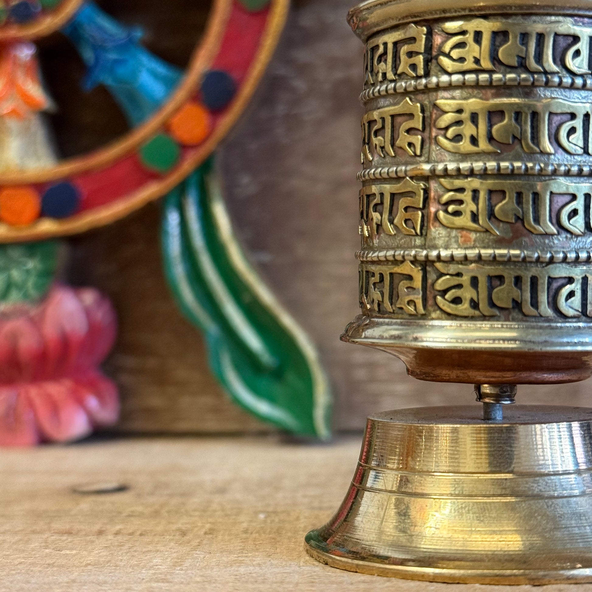 This Mini Tabletop Prayer Wheel is a sacred object of quiet power and devotion. Though small in size, it contains great merit—filled with countless scrolls of the Om Mani Padme Hum mantra, the heart-essence of compassion.

Crafted from a mix of copper and solid brass, the wheel features four lines of sacred mantra around its exterior and rests on a finely detailed brass base. According to Tibetan Buddhist tradition, spinning the prayer wheel is equal in merit to reciting the mantra aloud, purifying negativi
