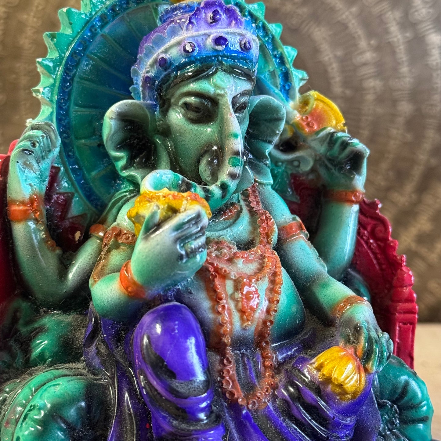 Hand-painted 15 cm resin Ganesh statue holding lotus, axe, and sweets.