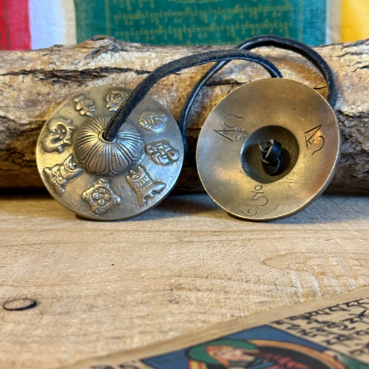 A&nbsp;Tingsha is a small pair of hand-cymbals traditionally used in Tibetan Buddhist practices. They consist of two small, round metal plates connected by a leather or fabric strap. When struck together, they produce a clear, high-pitched, and resonant tone.