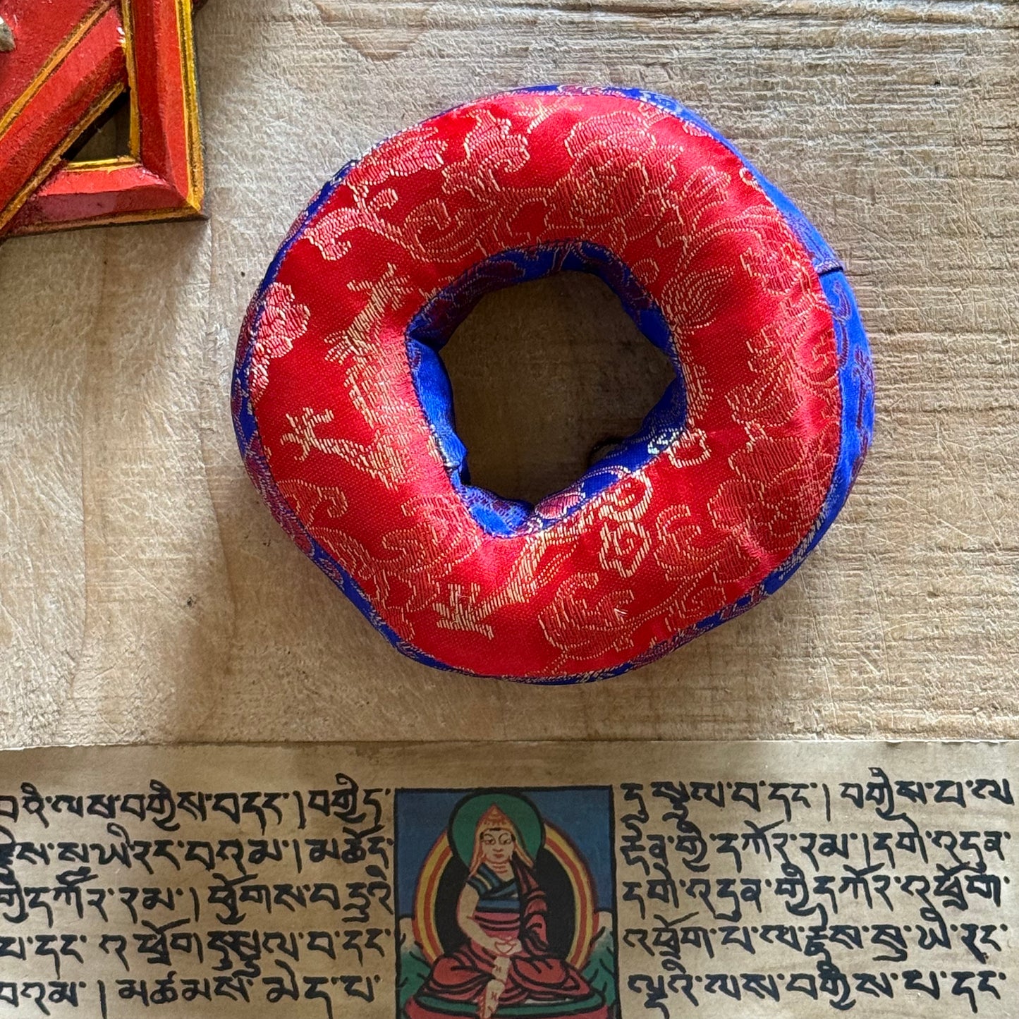 These round brocade cushions, carefully stitched, are designed to support smaller singing bowls. Made from a blend of brocade fabrics, they offer a stable foundation. Each cushion is handmade in Nepal under Fair Trade practices and measures about 12 cm in diameter.