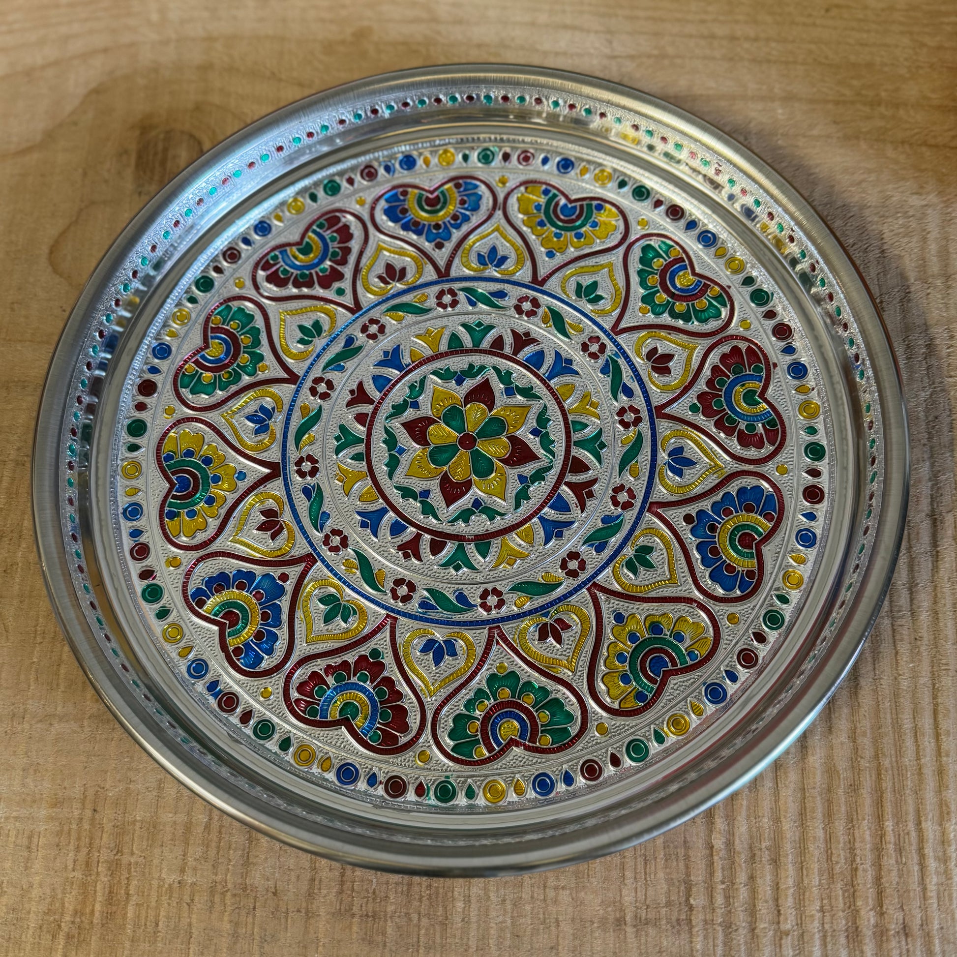 The Mandala Offering Tray is a beautifully decorated Indian dish made from aluminum. It is traditionally used for offering items such as candles, incense, flowers, or food in ceremonies and rituals.

Key Features:
Material: Aluminum, with intricate mandala decorations.
Traditional Use: Perfect for placing offerings like flowers, food, candles, or incense.
Size: 28 cm diameter and 2.5 cm height.
Care Note: Not heat-resistant. Ensure to use a fireproof surface when burning candles or incense on the tray to pr