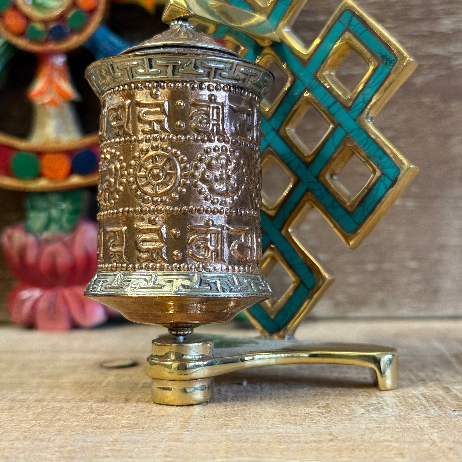The Endless Knot, painted in a turquoise-green hue, symbolizes the interdependence of all things and the infinite nature of wisdom. Each spin of the copper wheel turns the printed mantras within, radiating blessings and merit in every direction.

A spiritual tool to remind you of the ever-present Dharma, whether in quiet practice or daily life