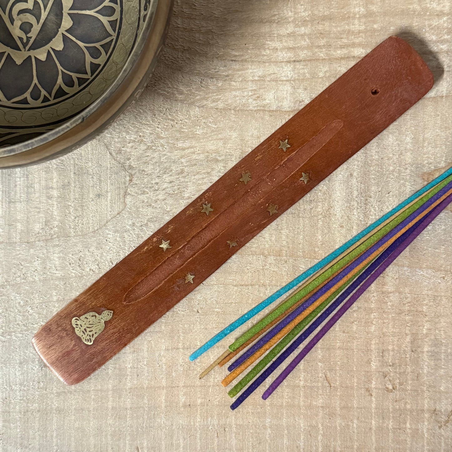 Handcrafted wooden incense holder with brass Buddha inlay for clean, mindful burning and peaceful ritual spaces.
