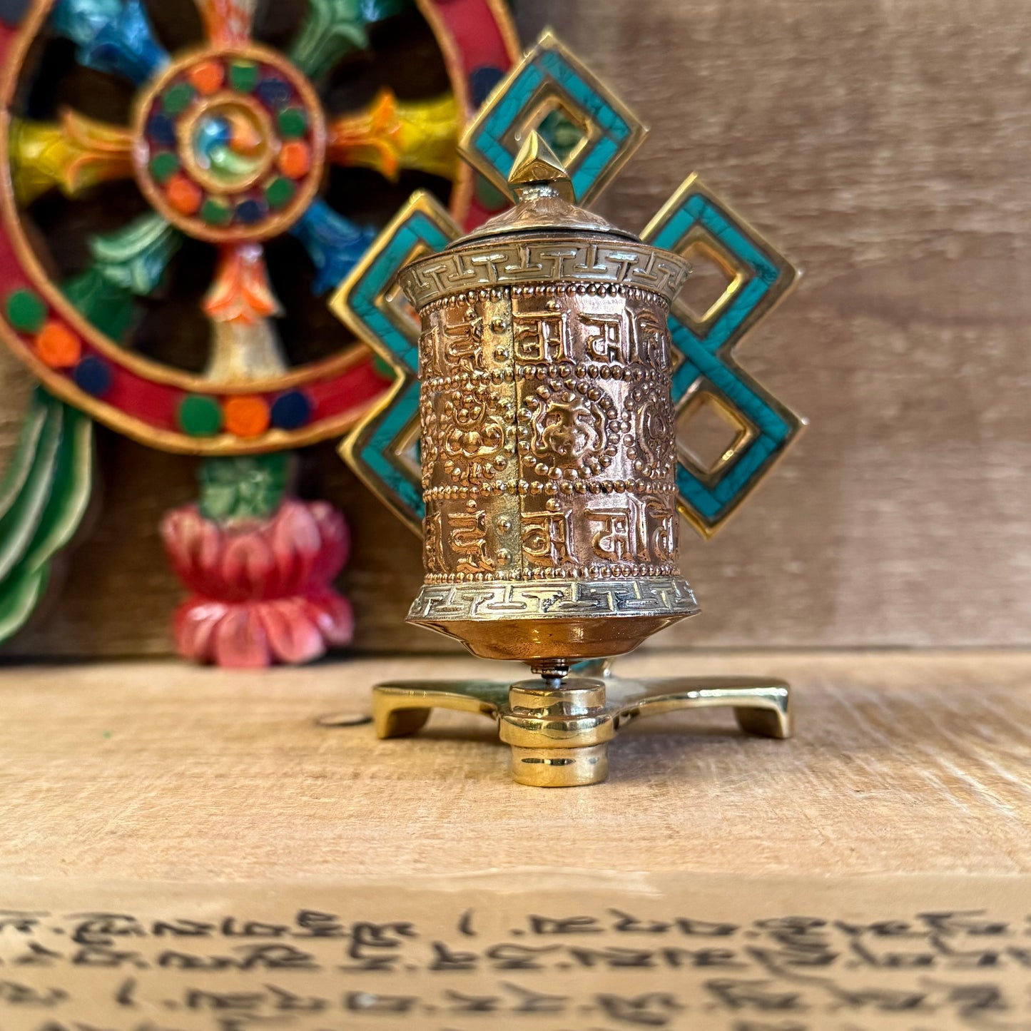 The Endless Knot, painted in a turquoise-green hue, symbolizes the interdependence of all things and the infinite nature of wisdom. Each spin of the copper wheel turns the printed mantras within, radiating blessings and merit in every direction.

A spiritual tool to remind you of the ever-present Dharma, whether in quiet practice or daily life