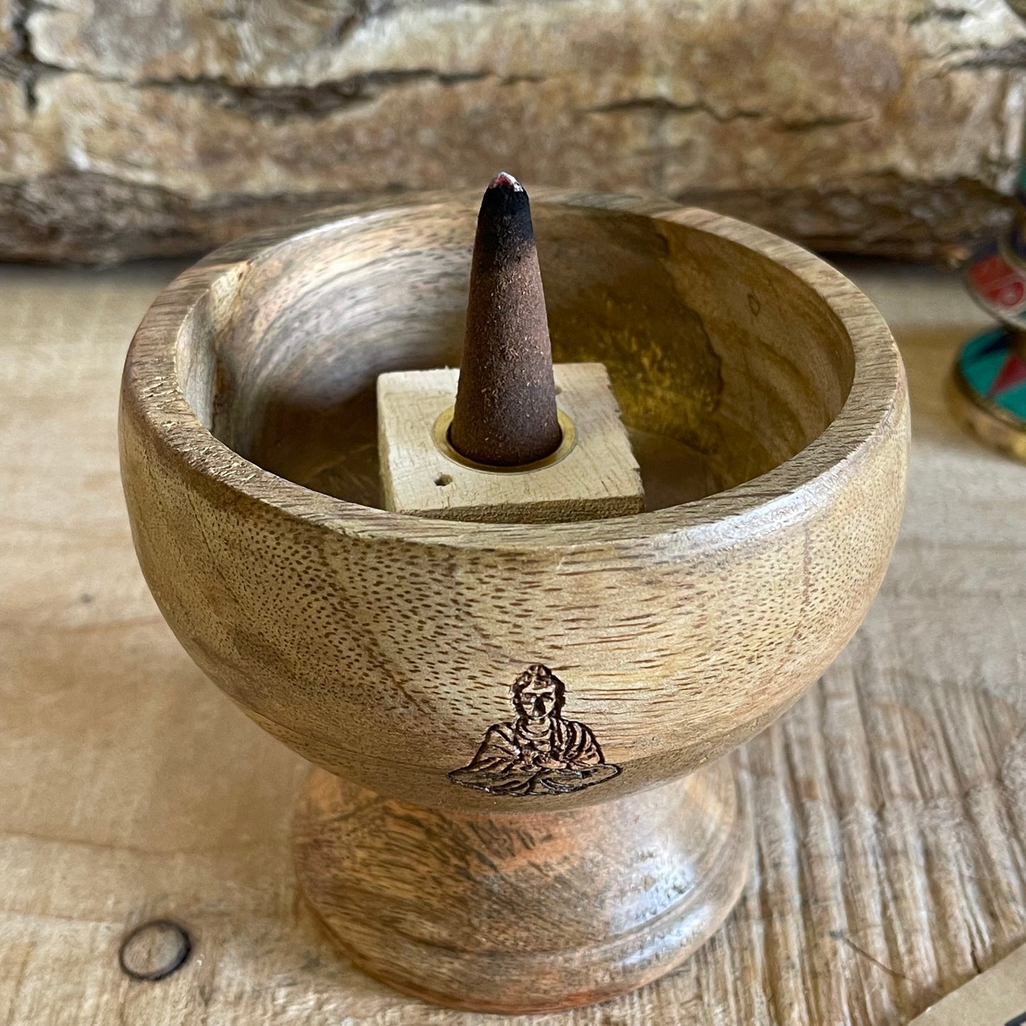 This incense holder is a compact yet intricate piece, measuring 11 cm across and standing 10 cm tall. Its dual-purpose design accommodates both incense sticks and cones, making it versatile for different types of incense rituals. The bowl-shaped holder features a serene Buddha symbol etched with precision on the inside surface, creating a focal point that enhances its spiritual ambiance. The Buddha engraving adds an element of tranquility, inviting a reflective, meditative quality to the space. Ideal for al