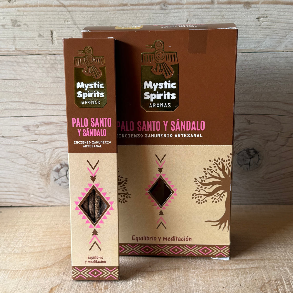 Two boxes of Mystic Spirits Aromas Palo Santo y Sándalo incense sticks standing upright against a light wood plank background.