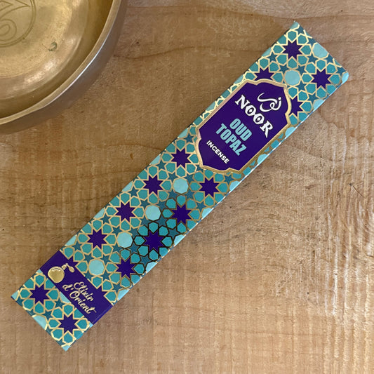 Discover Noor Oud Topaz Incense, a refined blend of oud, saffron, patchouli, and sandalwood with a warm, sophisticated Middle Eastern aroma.