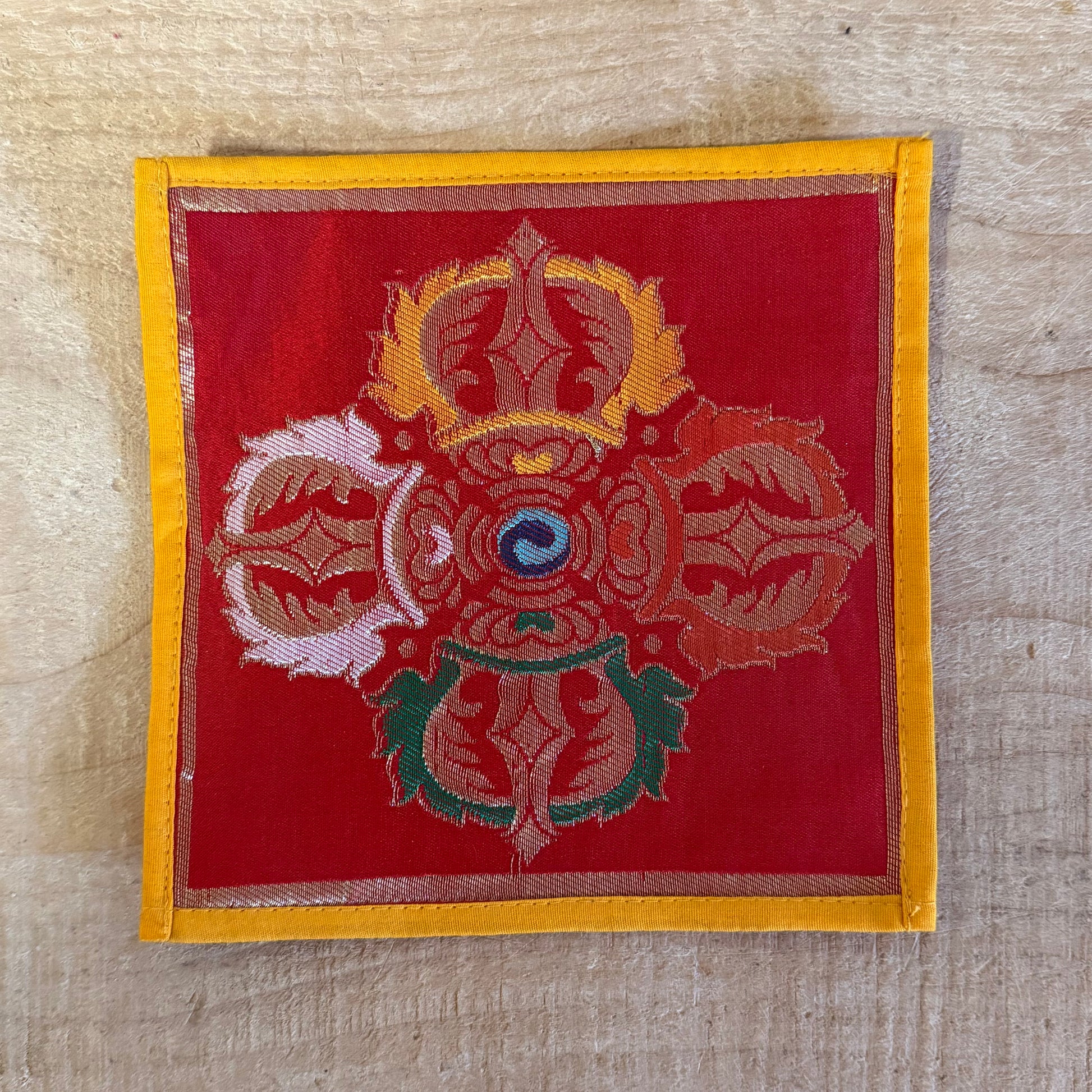 This Mini Tibetan altar cloth features a Dorje (Vajra), symbolizing the indestructible power of love, compassion, and spiritual protection. Handcrafted from thick silk brocade, this silk brocade altar mat is perfect for placement under a singing bowl, standing Dorje, or other sacred Buddhist ornaments.